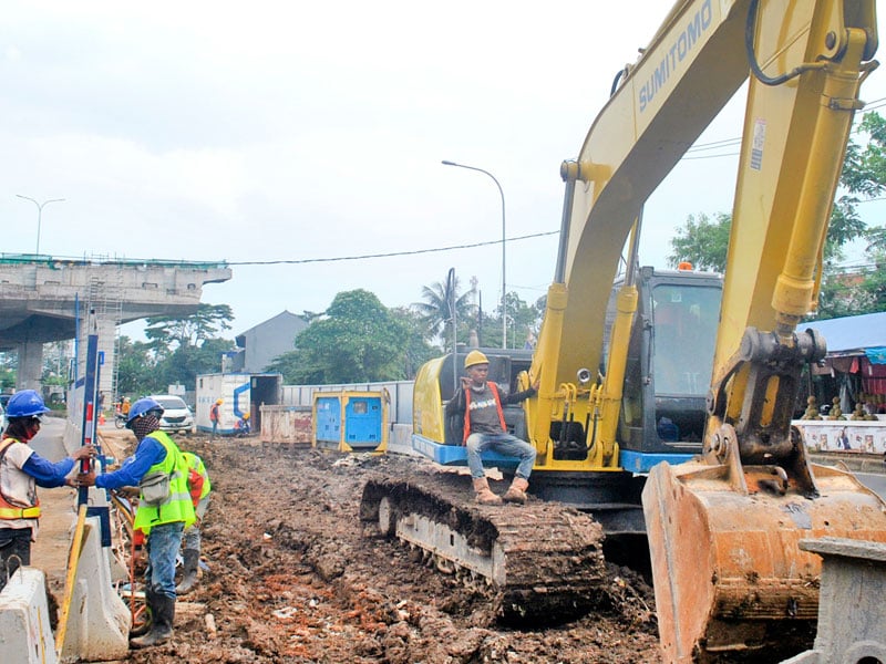 Pekerja dengan alat berat mengerjakan pembangunan tol Bogor Ring Road (BORR)