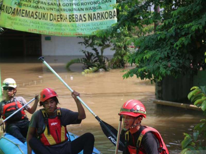 Anggota SAR menaiki perahu karet untuk menjemput warga RT 01, RW 06, Kelurahan Cililitan, Jakarta Timur  yang masih bertahan di rumahnya.