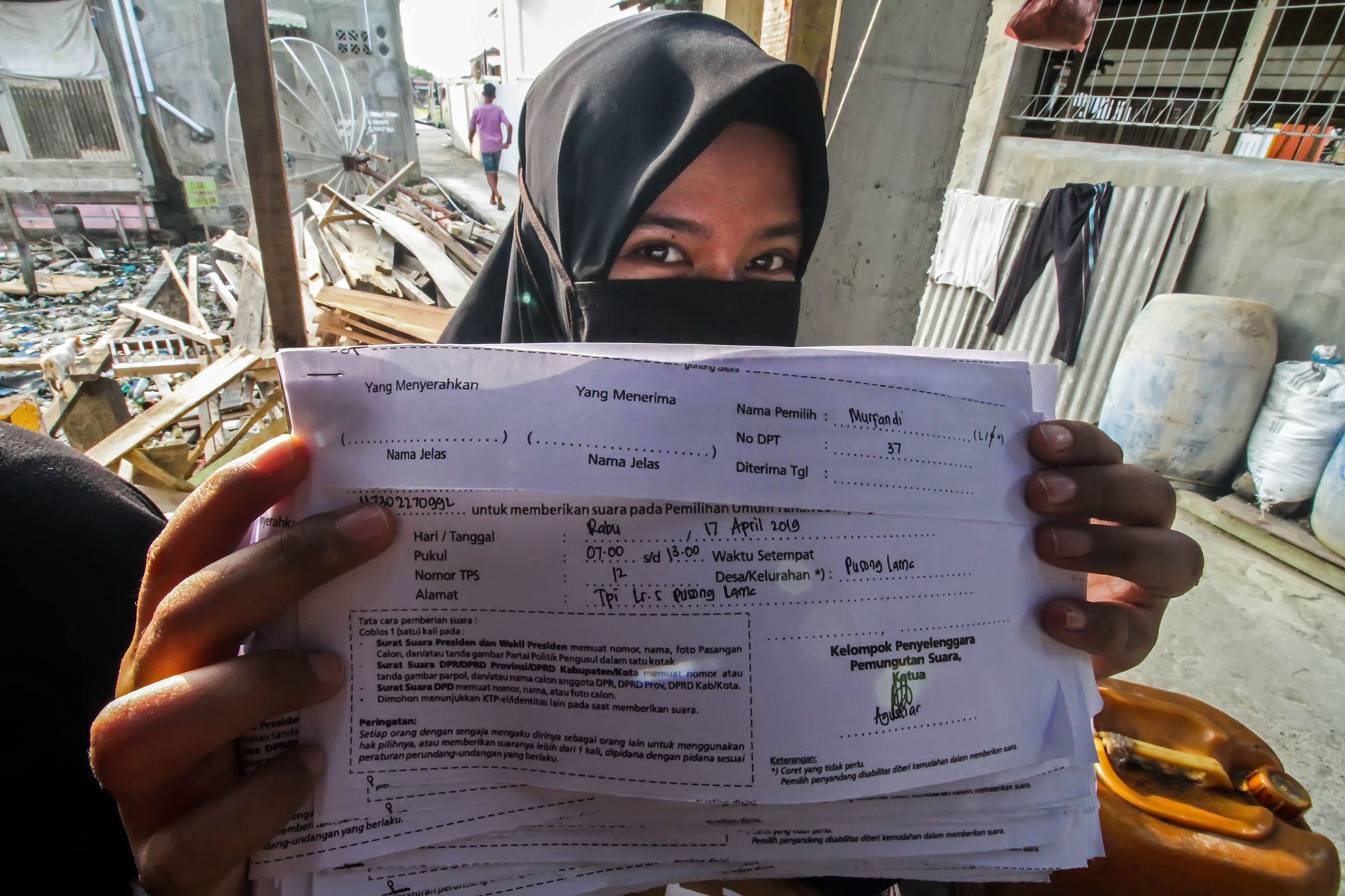  Petugas Kelompok Penyelenggara Pemungutan Suara (KPPS) menunjukkan surat pemberitahuan pemungutan suara kepada pemilih model C6