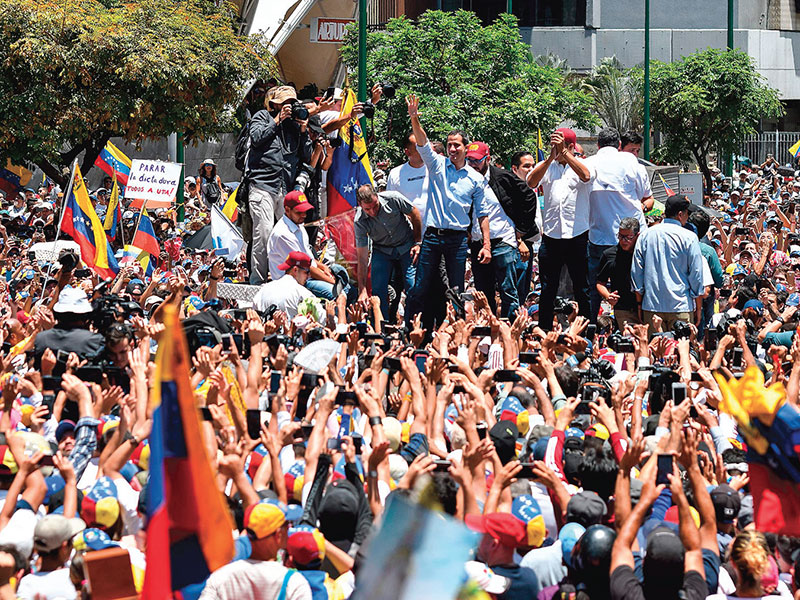 PROTES PRESIDEN NICOLAS MADURO: Pemimpin oposisi Venezuela, Juan Guaido (tengah), melambaikan tangan saat aksi unjuk rasa di El Marques