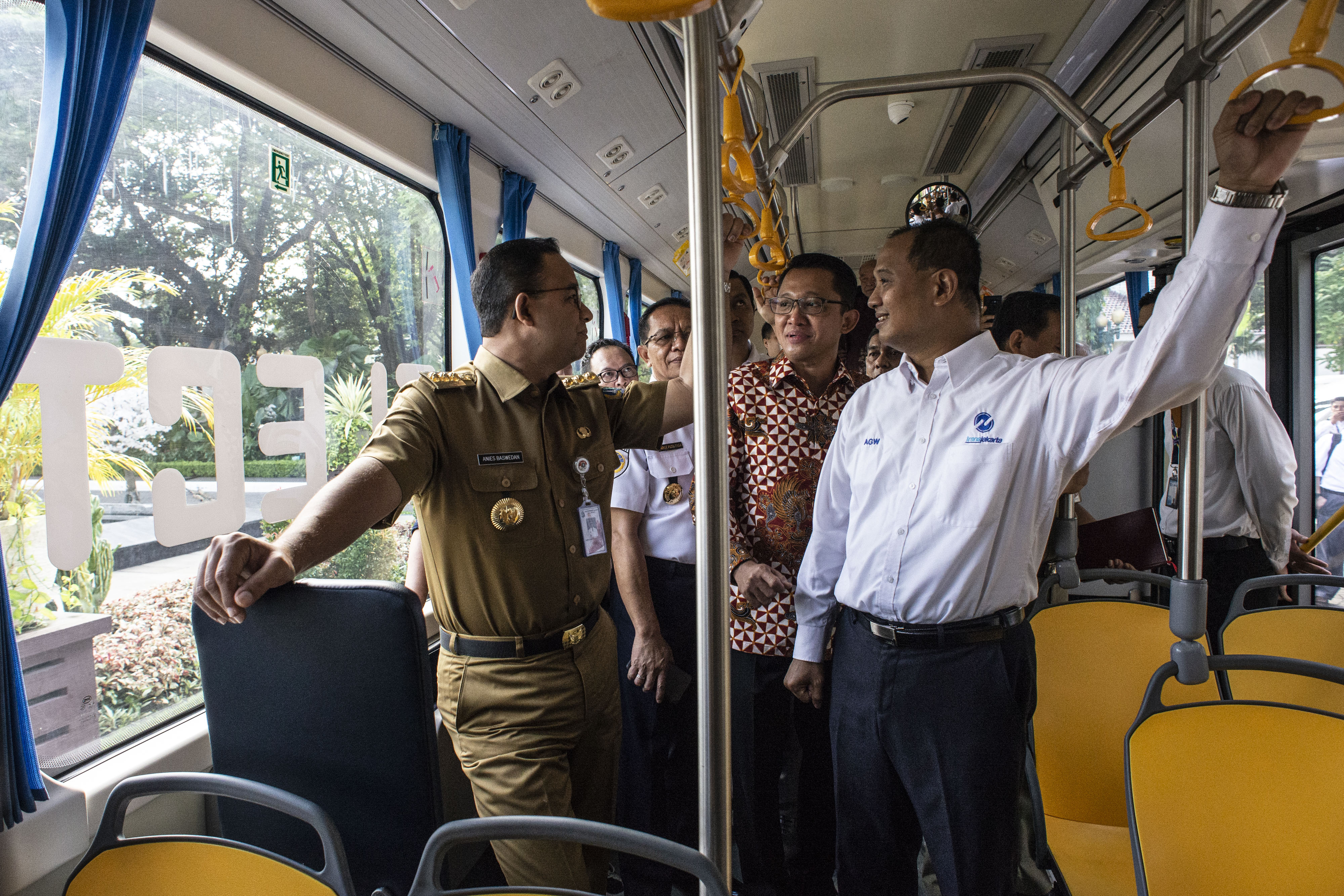 Gubernur DKI Jakarta Anies Baswedan (kiri), Dirut TransJakarta Agung Wicaksono (kanan) berbincang di dalam bus listrik.