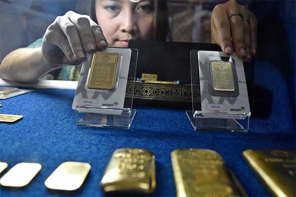 Petugas menunjukkan imitasi emas logam mulia produk PT Aneka Tambang (Antam) yang dipamerkan di gerai Antam dalam sebuah pameran di Ungaran,