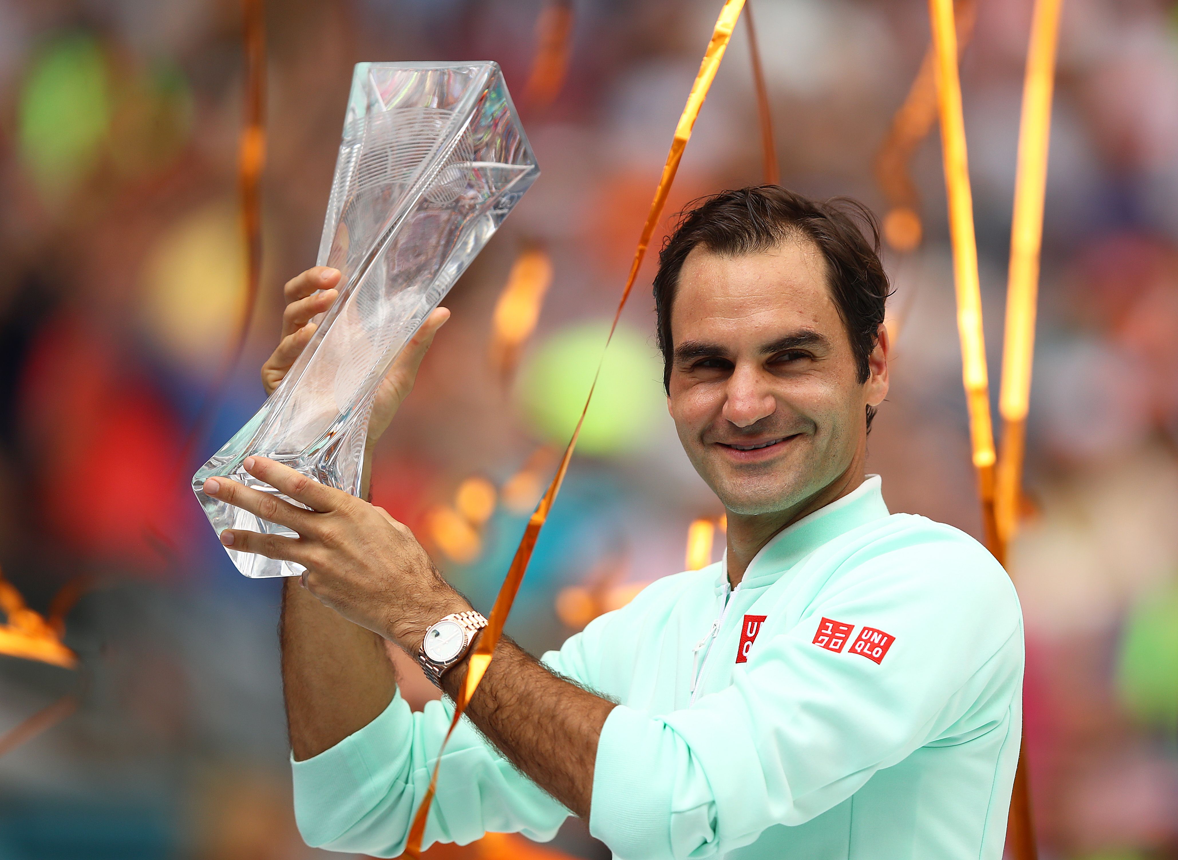 Roger Federer dari Swiss merayakan dengan trofi pemenang melawan John Isner dari AS di final pada hari keempat belas tenis Miami Terbuka 