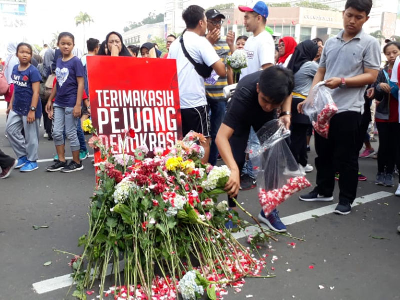 Relawan milenial Jokowi-Ma'ruf mengadakan aksi doa dan tabur bunga pada Minggu, (28/4) di kawasan bundaran HI Jakarta. 