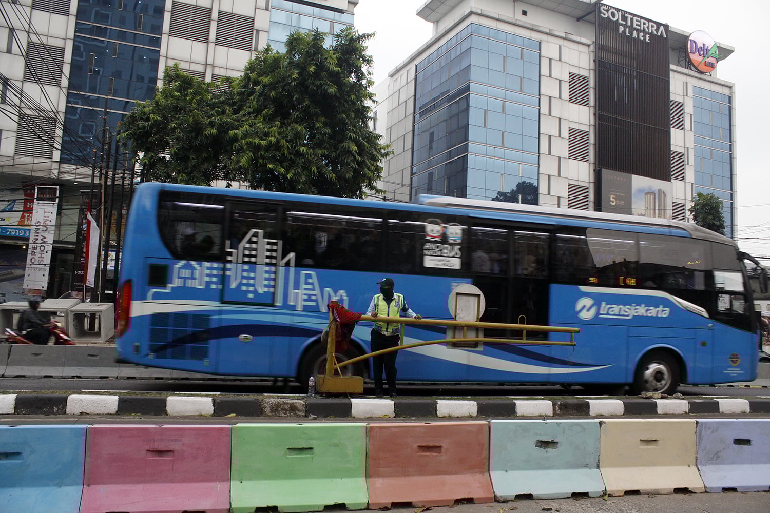 : Bus TransJakarta melintas di dekat pembatas jalan 