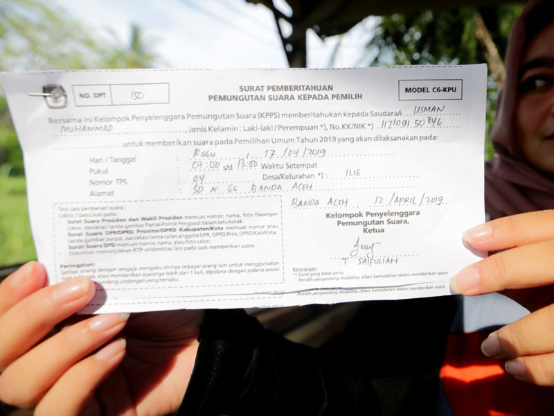 Warga memperlihatkan surat pemberitahuan pemungutan suara kepada pemilih model C6.
