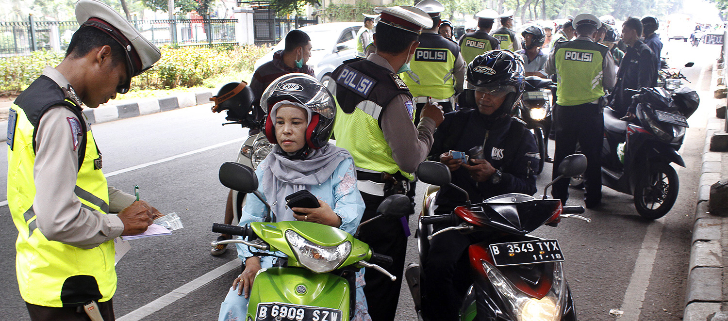  Polisi menilang pengendara motor saat menggelar Operasi Zebra di kawasan Tanjung Barat, Jakarta, Minggu (4/11/2018)