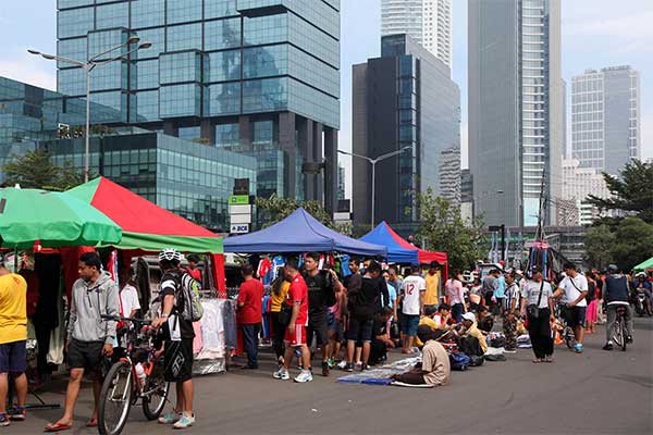 Pedagang kaki lima berjualan di Jalan Blora yang dekat dengan area Hari Bebas Kendaraan Bermotor (HBKB), Minggu (27/12).