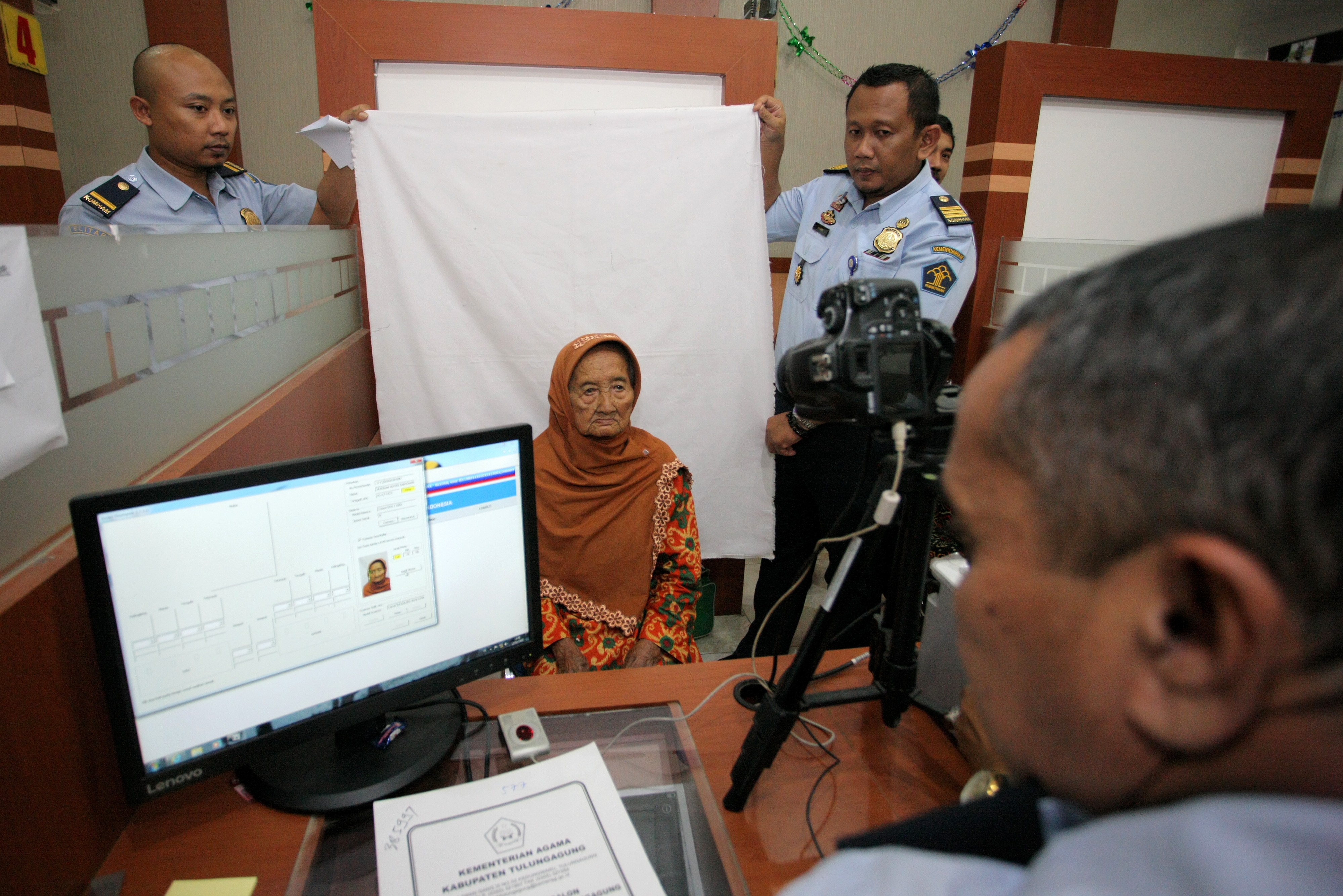 Petugas Imigrasi melayani pembuatan paspor Jemaah Calon Haji Indonesia (JCHI) lansia di Blitar, Jawa Timur, Selasa (12/2). 