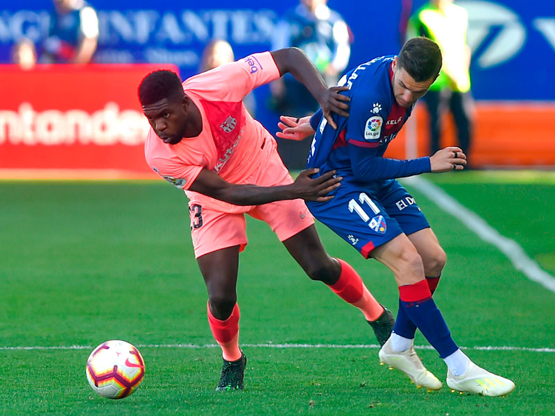 Pemain Barcelona bertahan Samuel Umtiti (krir) berebut bola dengan penyerang SD Huesca Alex Gallar (kanan).