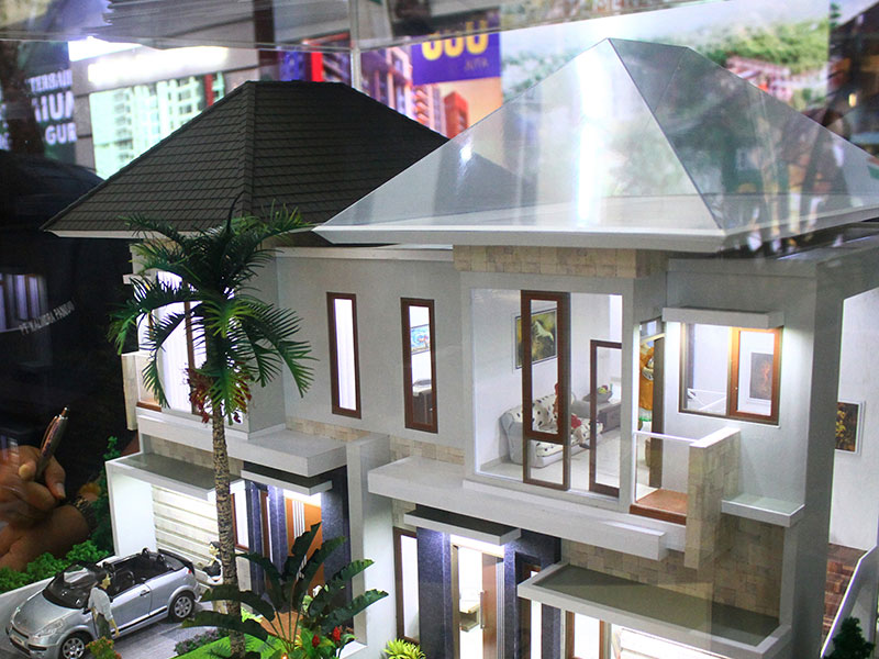 Pramuniaga menunjukkan maket properti rumah hunian yang dipajang dalam Pameran Properti di Malang Olympic Garden, Jawa Timur,Senin (19/11/2)