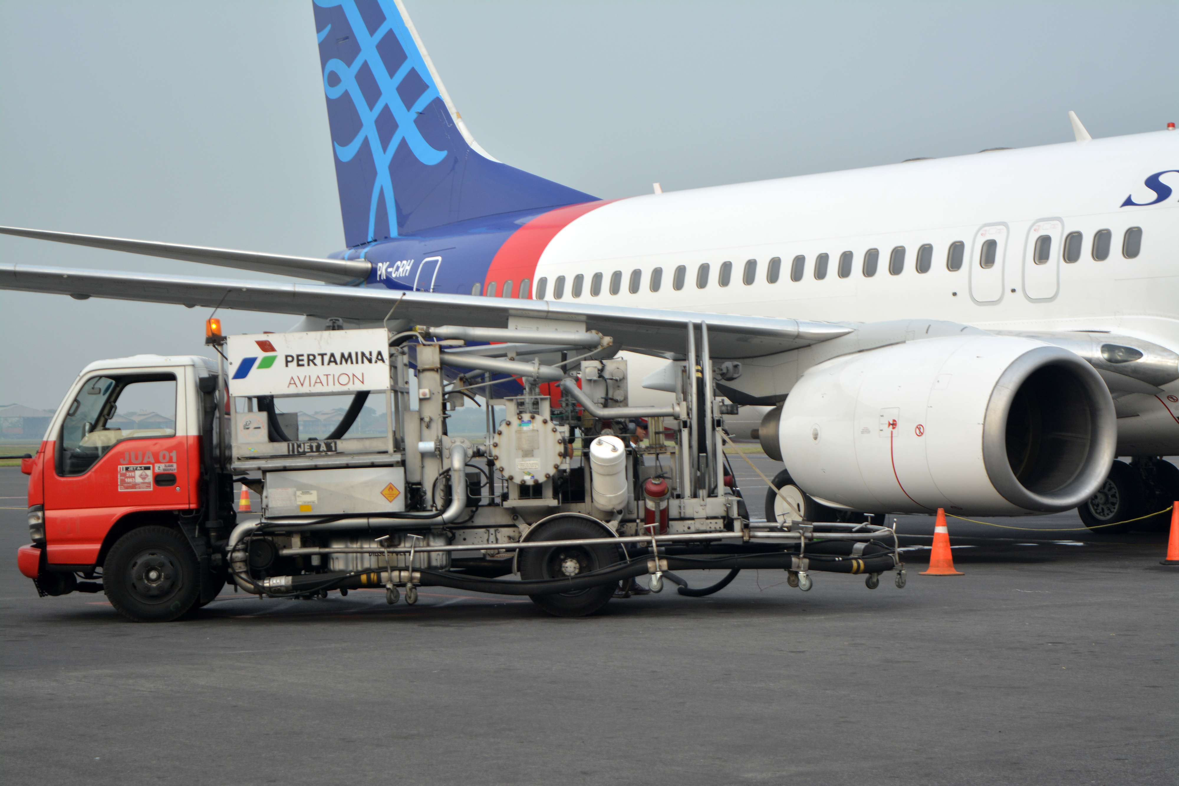 Petugas melakukan pengisian bahan bakar avtur ke dalam pesawat di Bandara Internasional Juanda, Sidoarjo