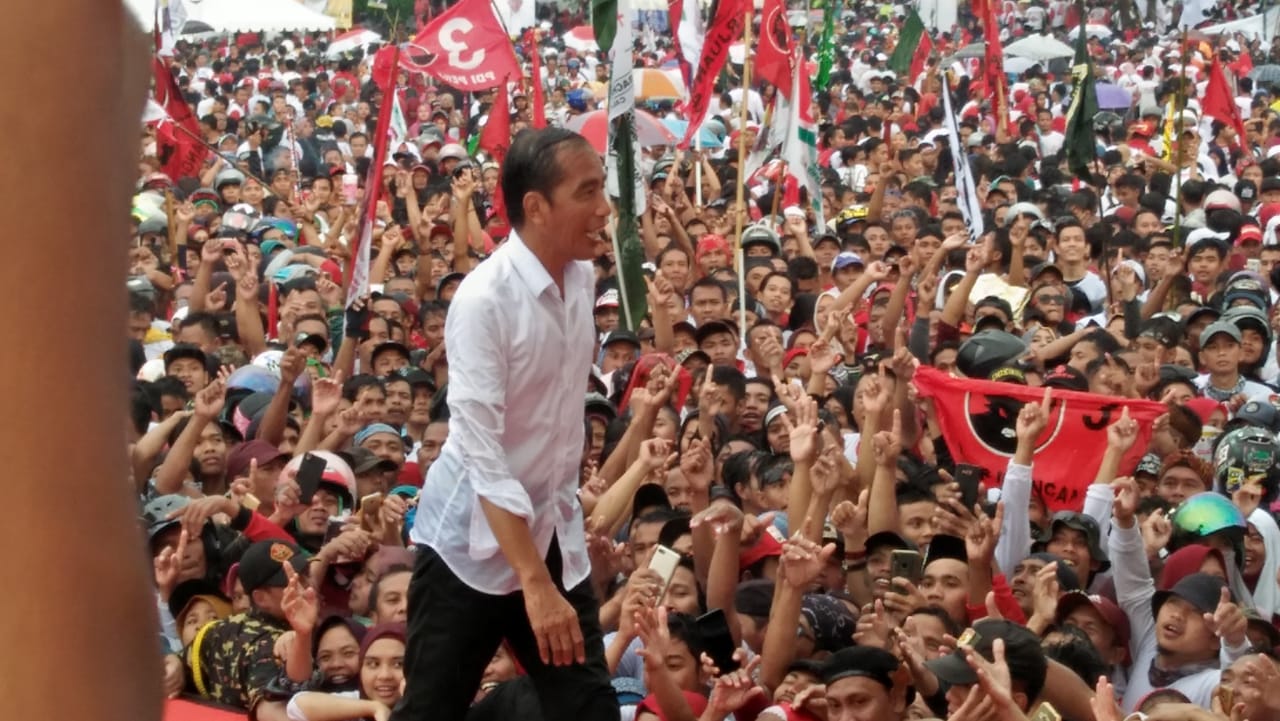 Capres nomor urut 01 Joko Widodo hujan-hujanan saat kampanye di Tegal, Jawa Tengah, Kamis (4/4).