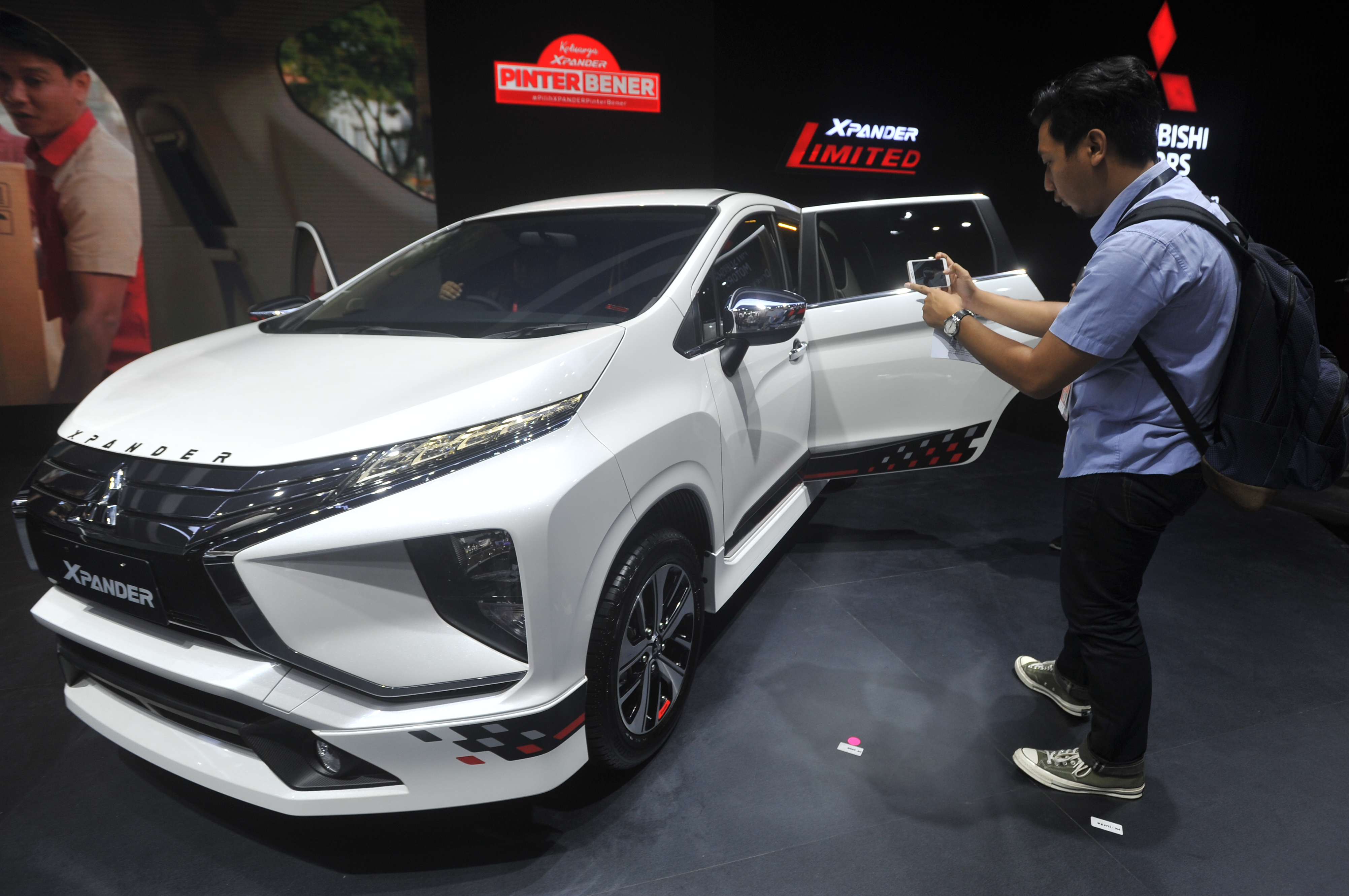 Pengunjung mengabadikan mobil Mitsubishi XPander Limited yang dipamerkan pada Indonesia International Motor Show 2019