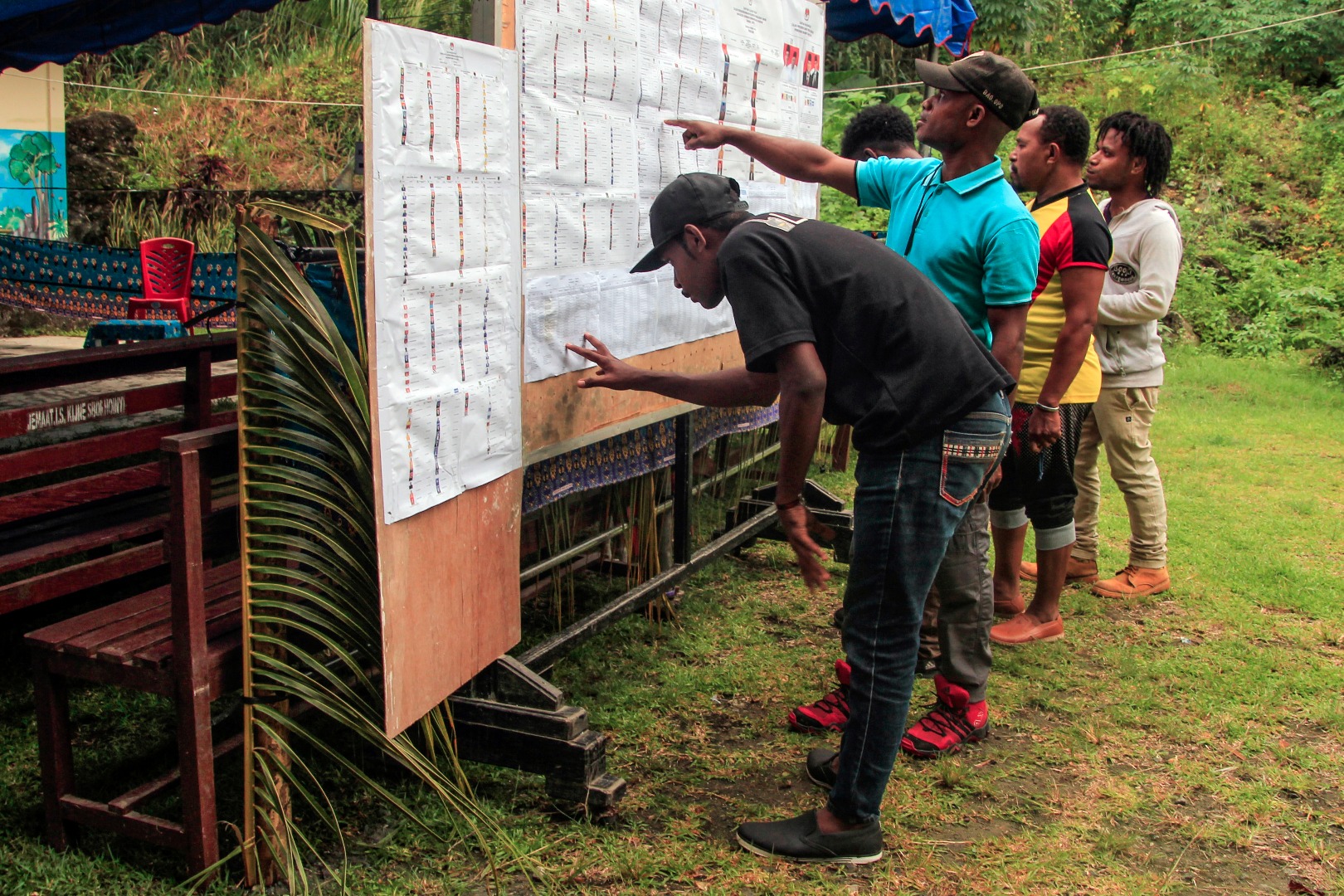 Warga mengamati daftar calon anggota legislatif pada Pemilu 2019 di TPS Kampung Wahno, Distrik Abepura, Jayapura