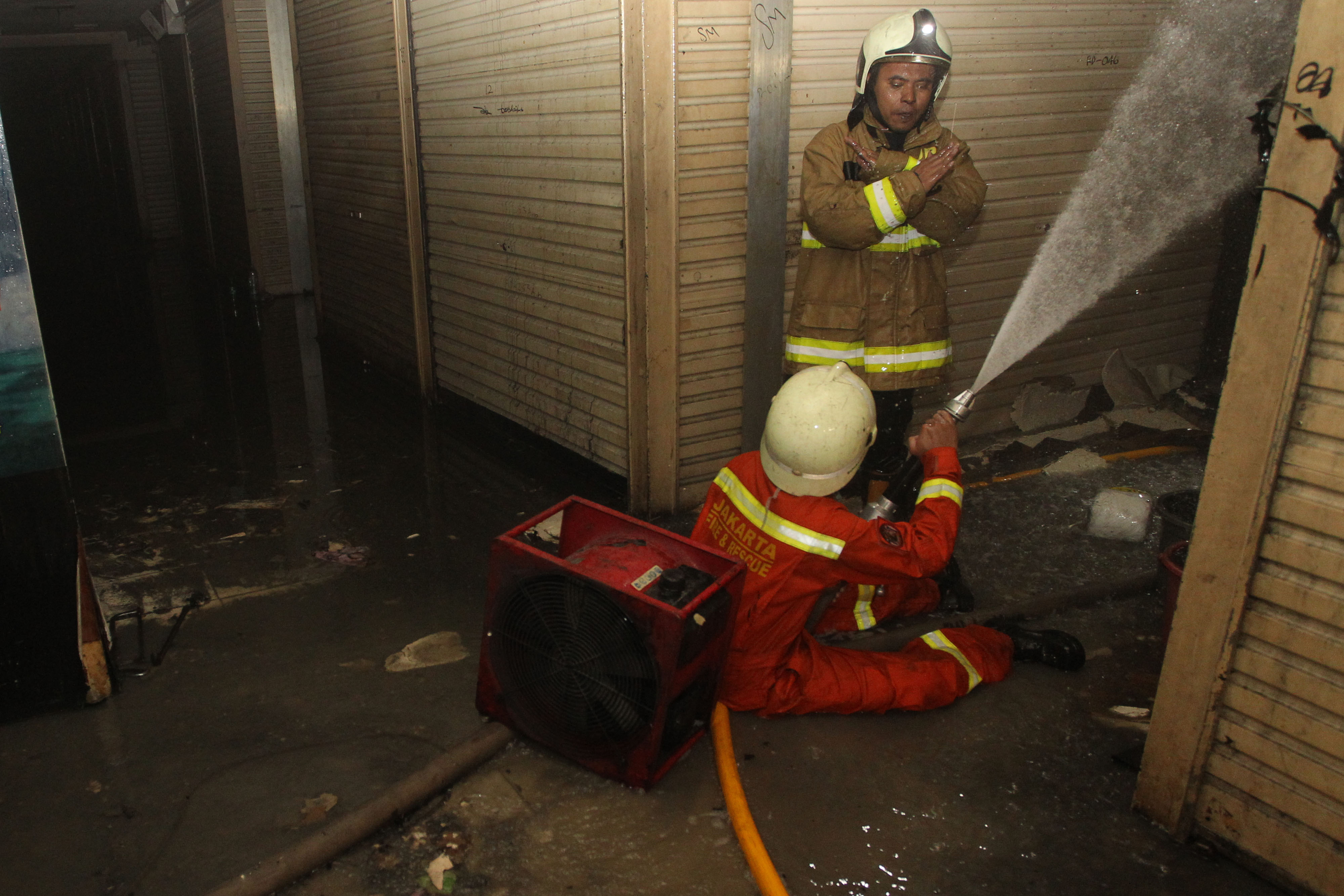  Petugas pemadam kebakaran melakukan pembahasan pada gudang pakaian yang terbakar di Blok C, Pasar Tanah Abang, Jakarta, Senin (22/4