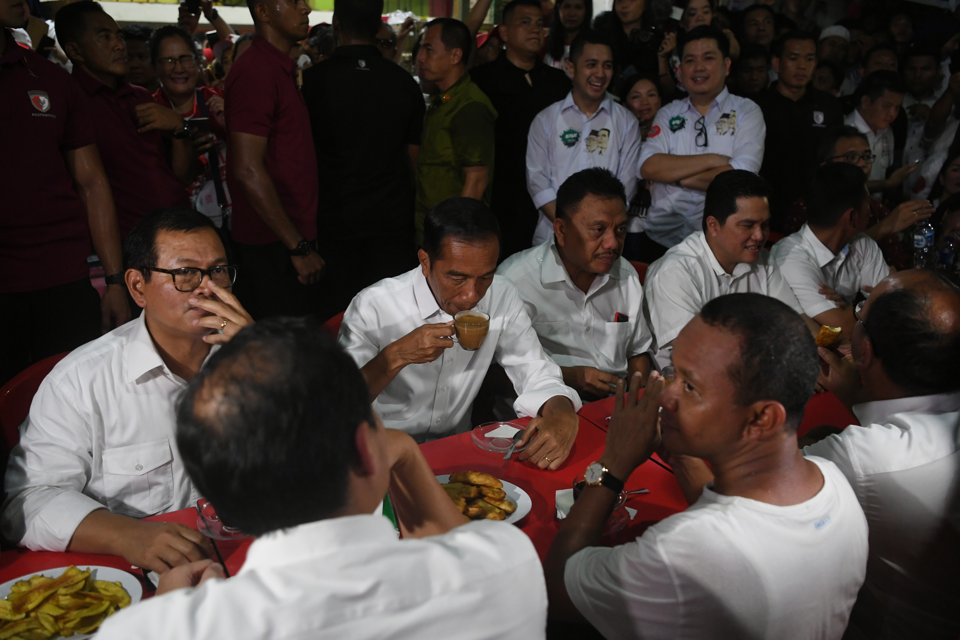 Capres nomor urut 01 Joko Widodo (kedua kiri) ngopi bareng milenial di kawasan Jalan Roda, Manado, Minggu (31/3).