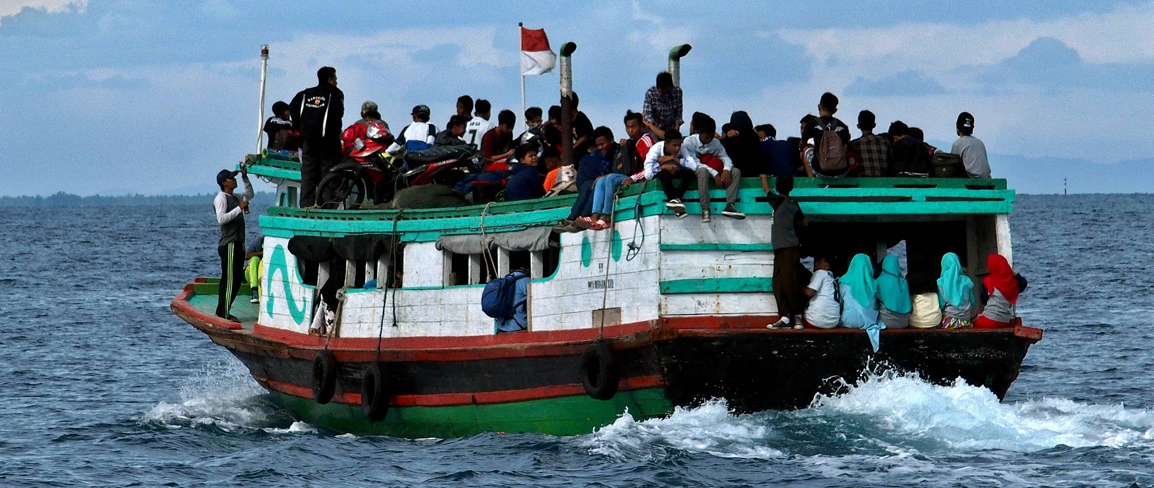 Kapal kayu tradisional mengangkut penumpang saat melintas di laut dekat Pulau Pramuka, Kepulauan Seribu, Jakarta