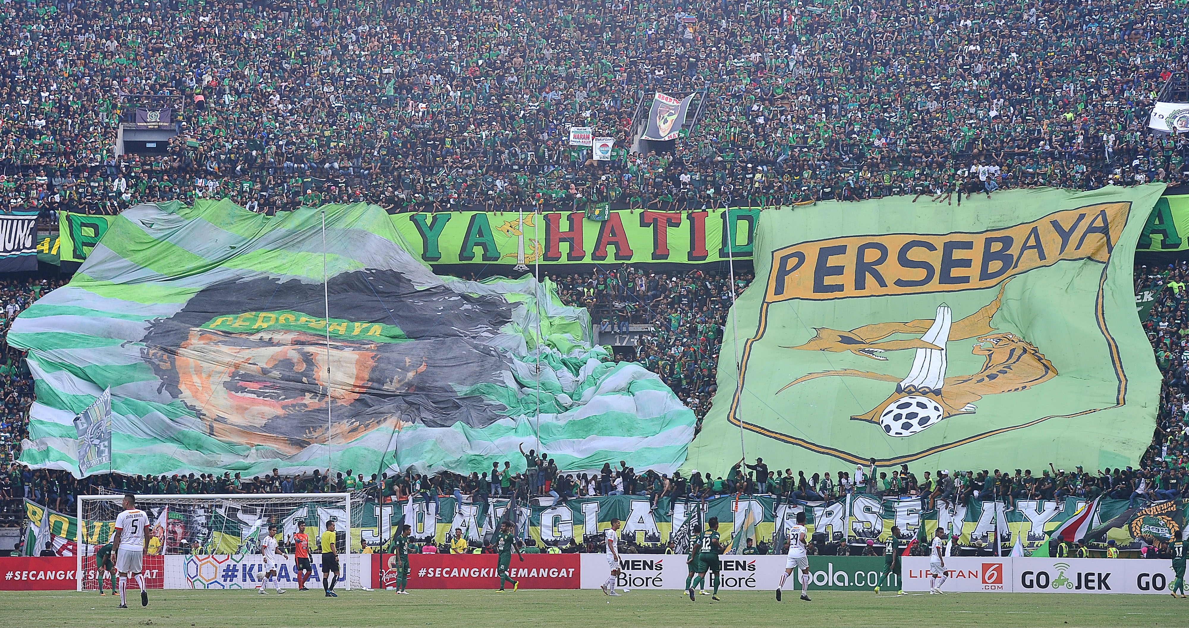 Suporter Persebaya Surabaya yang tergabung dalam Bonek Mania membentangkan koreografi ketika mendukung Persebaya Surabaya