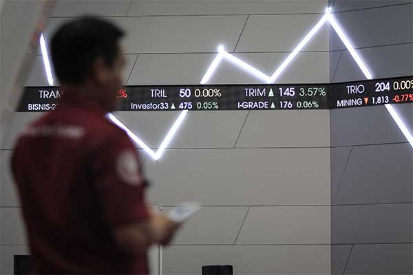Seorang pria mengamati layar pergerakan Indeks Harga Saham Gabungan (IHSG) di gedung Bursa Efek Indonesia, Jakarta, Jumat (5/4/2019).