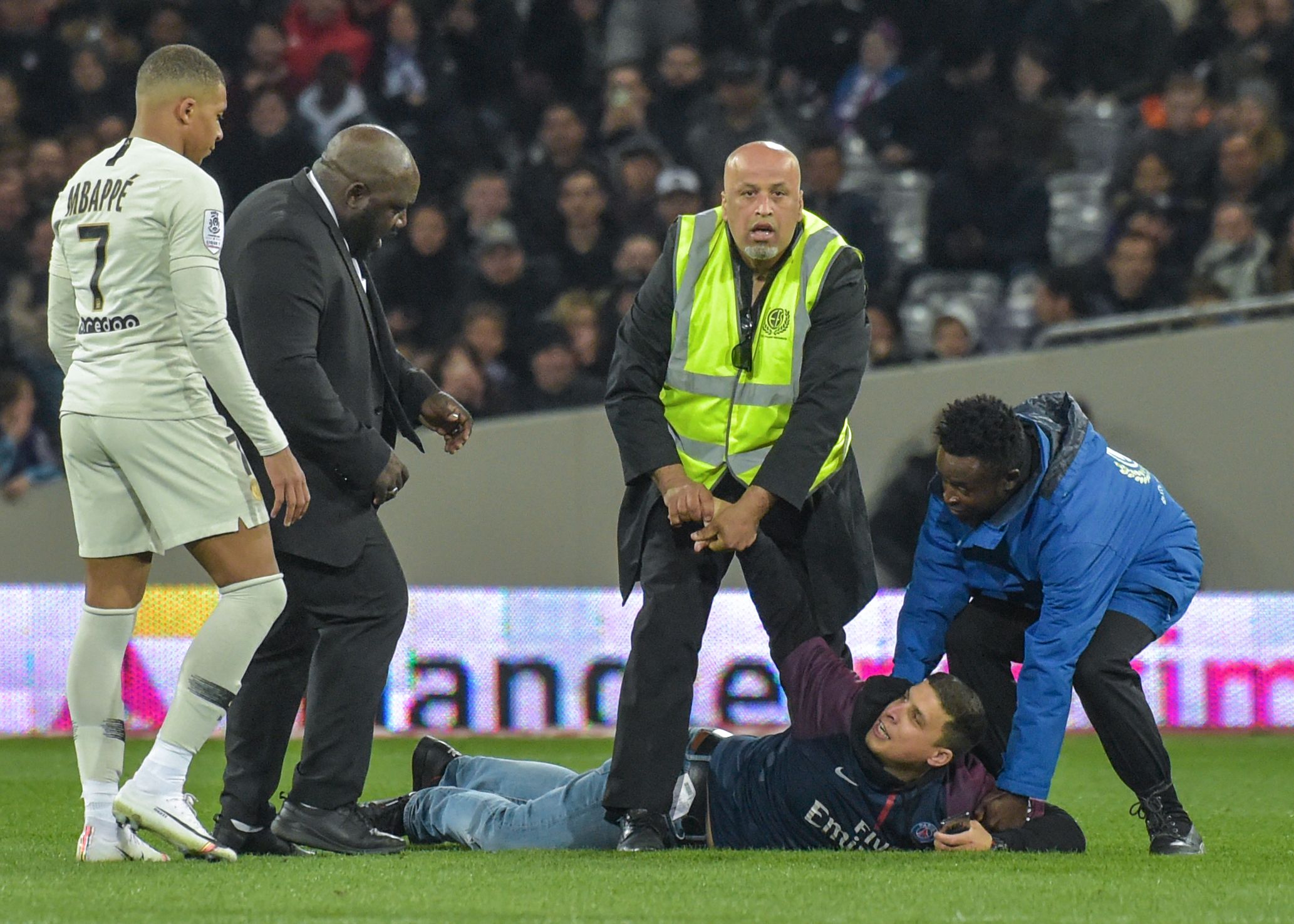 Pendukung PSG ditangkap setelah masuk ke lapangan dan mendekati Kylian Mbappe.