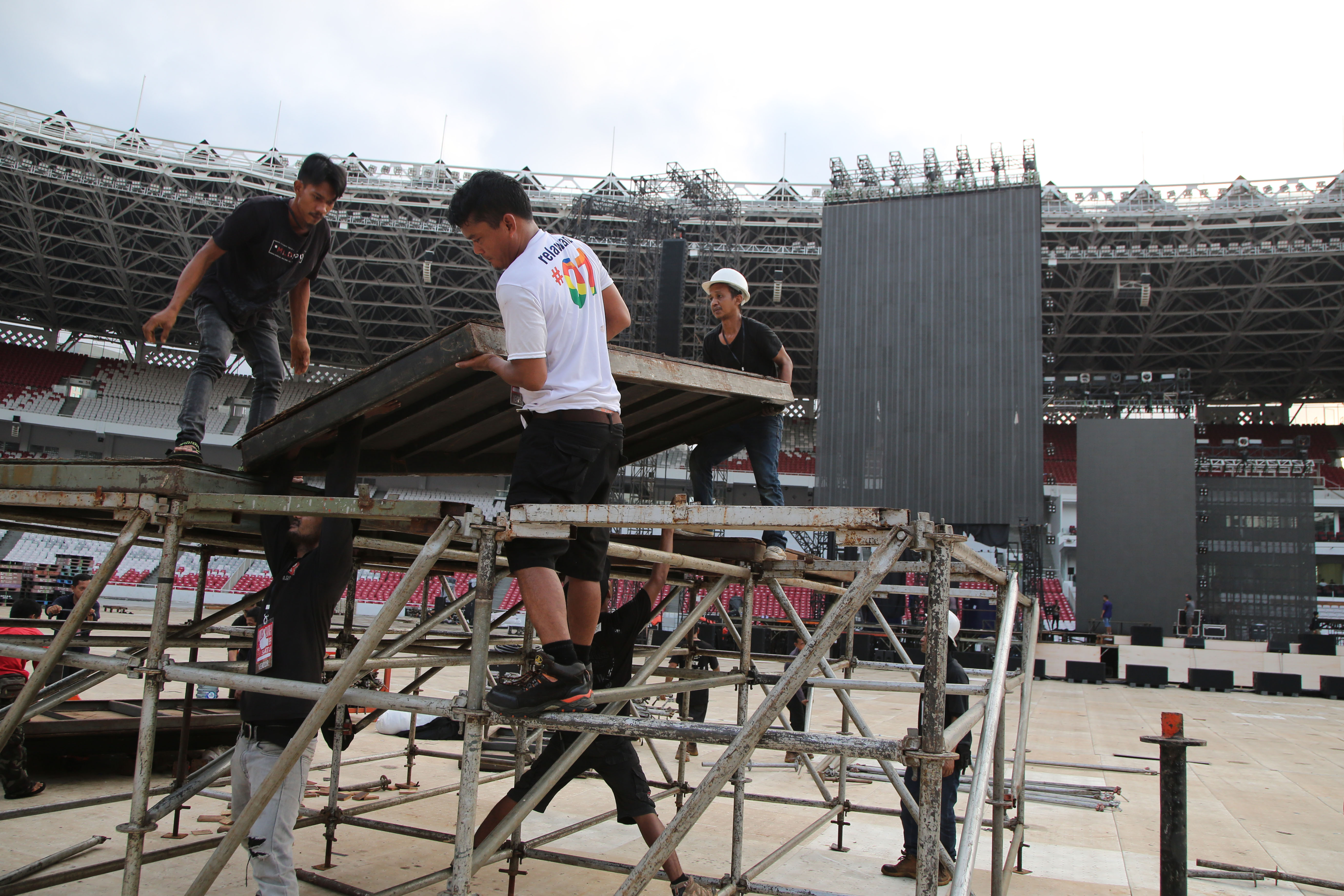 Pekerja mempersiapkan panggung dan berbagai perlengkapan jelang Konser Putih Bersatu di Stadion Utama Gelora Bung Karno 