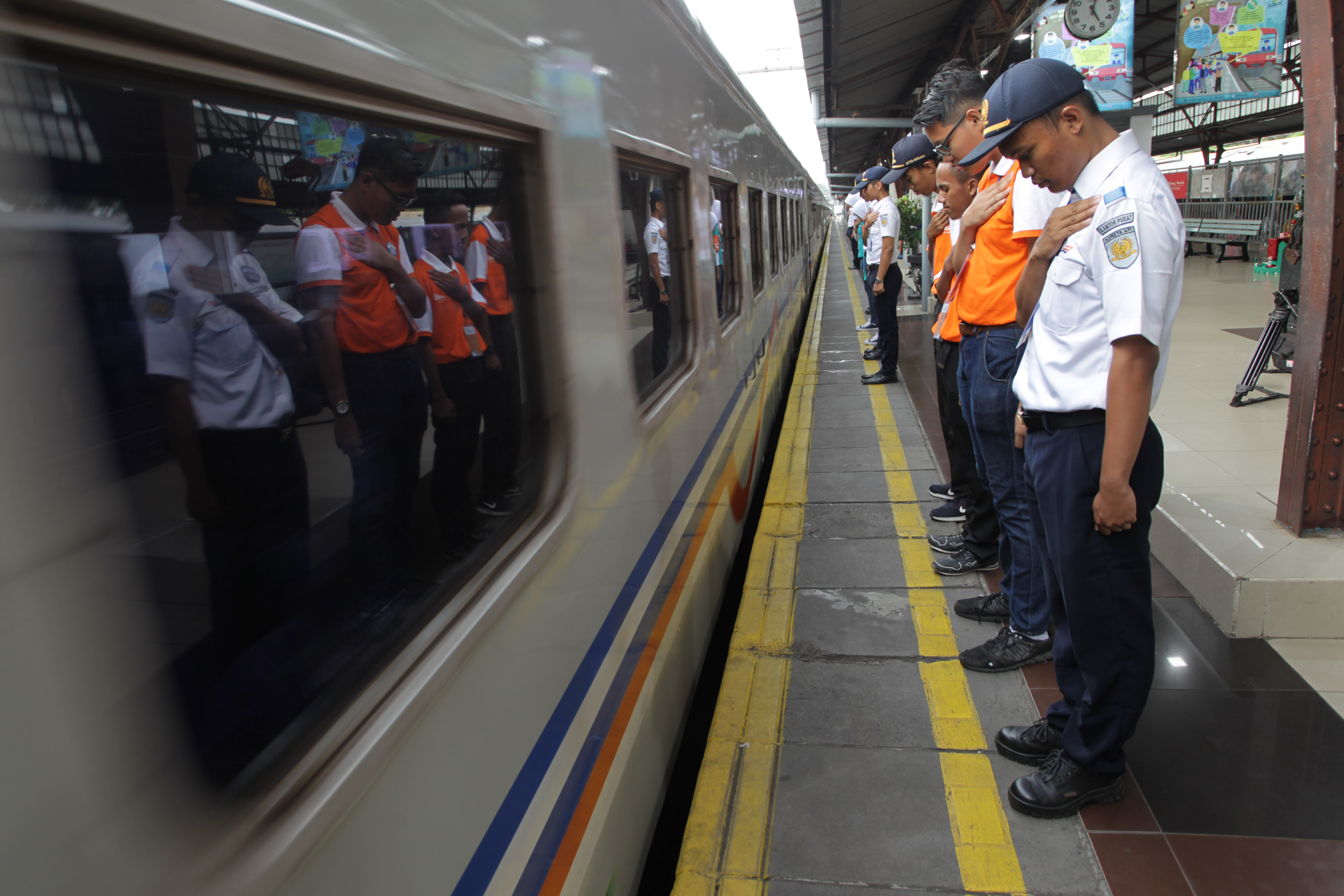 Sejumlah petugas memberikan penghormatan pada rangkaian kereta api Brantas Tambahan jurusan Jakarta-Blitar saat meninggalkan Stasiun Pasar S