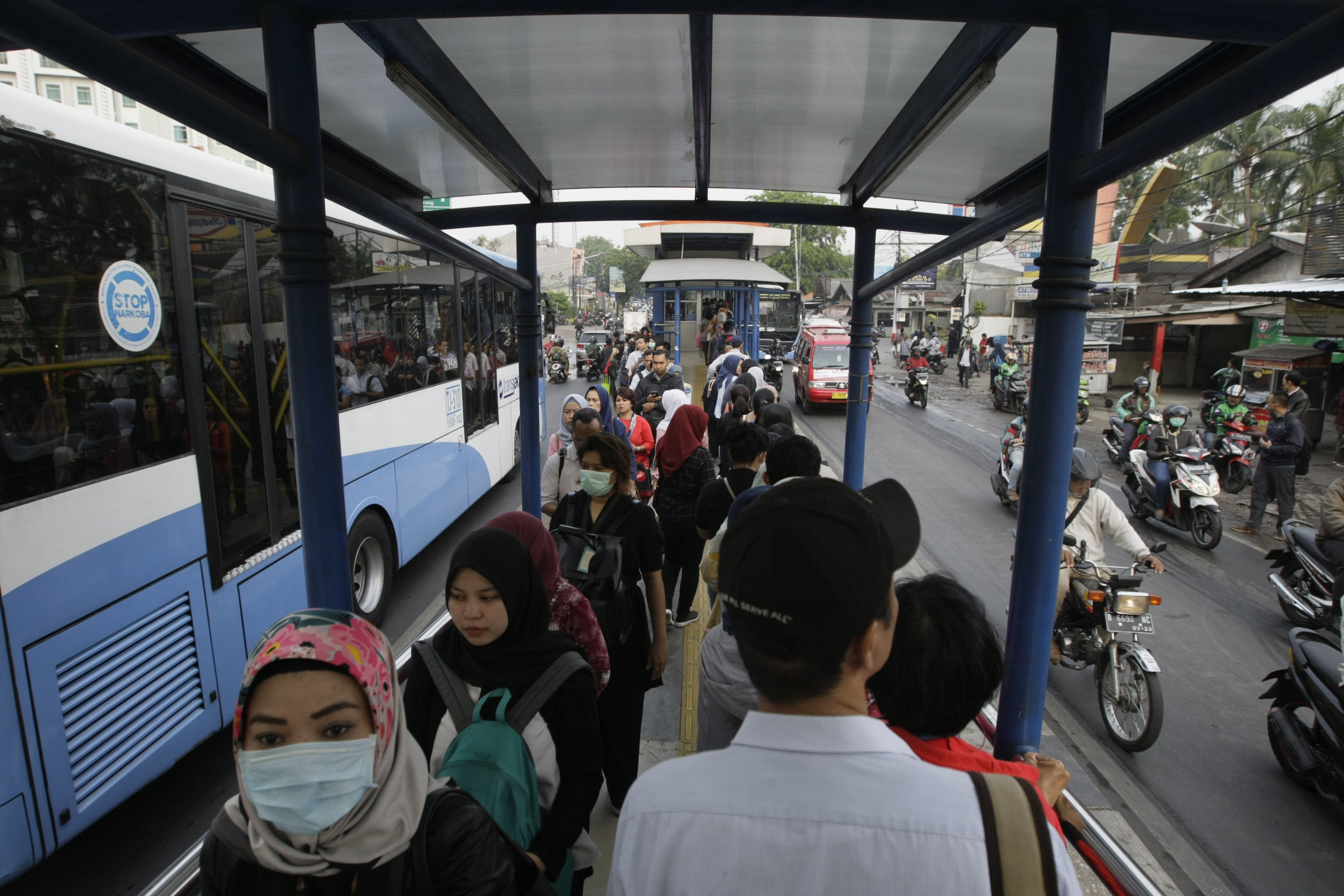 Antrian penumpang yang akan menaiki TransJakarta