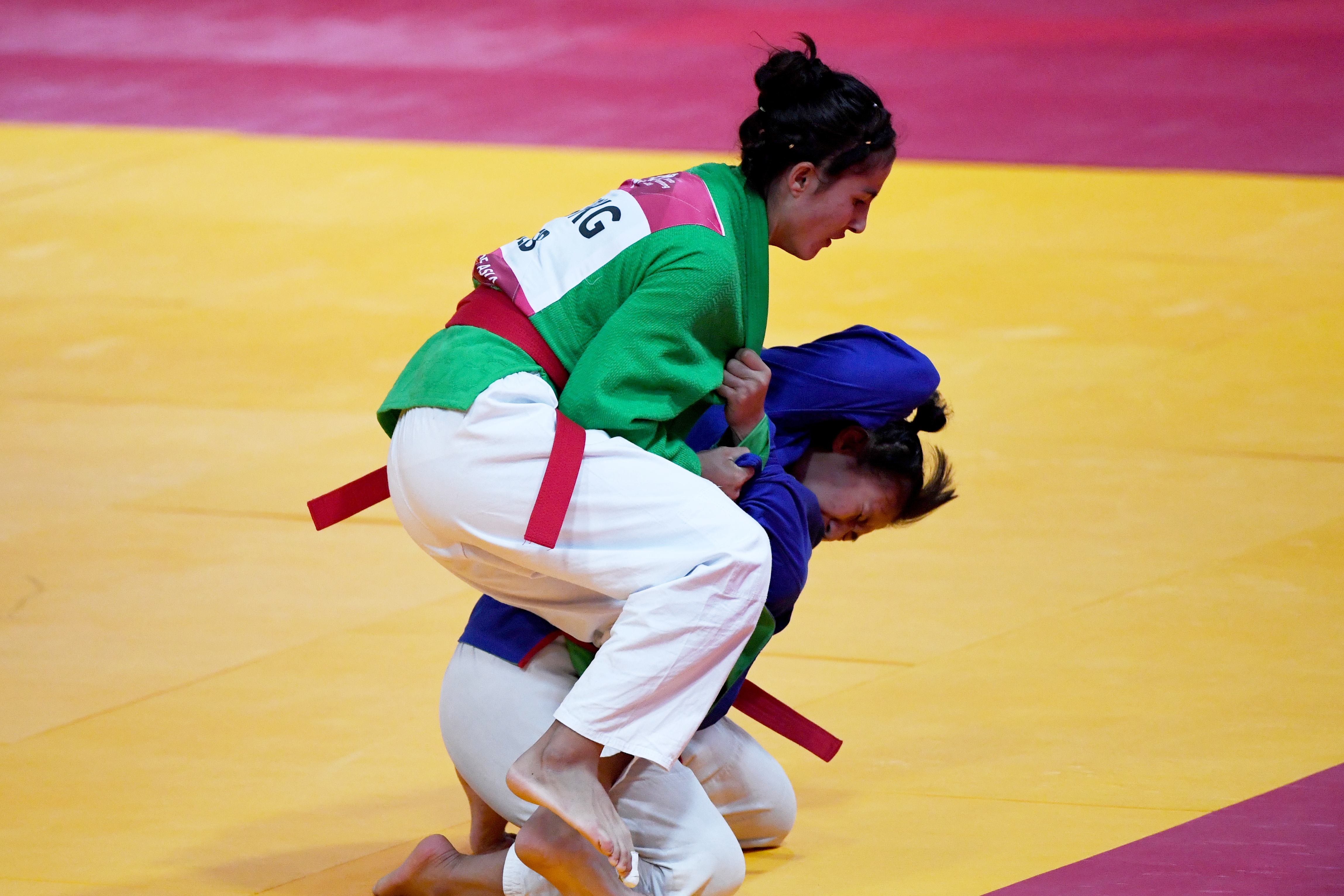 Atlet kurash Uzbekistan Dildor Shermetova (kiri) melakukan serangan terhadap atlet kurash Indonesia Khasani Najmu Shifa (kanan) 