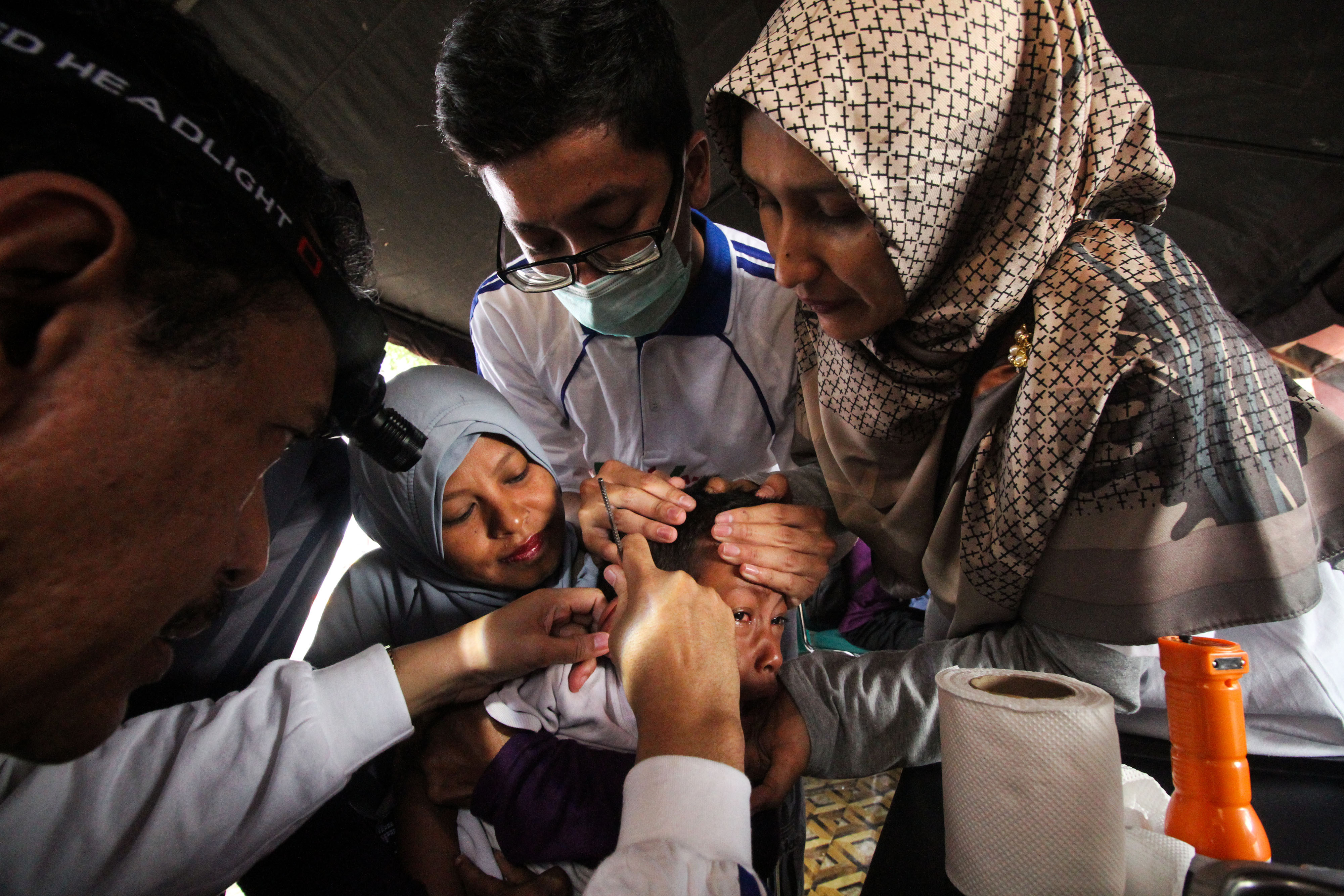  Dokter spesialis Telinga, Hidung dan Tenggorokan (THT) memeriksa telinga anak saat program kesehatan 