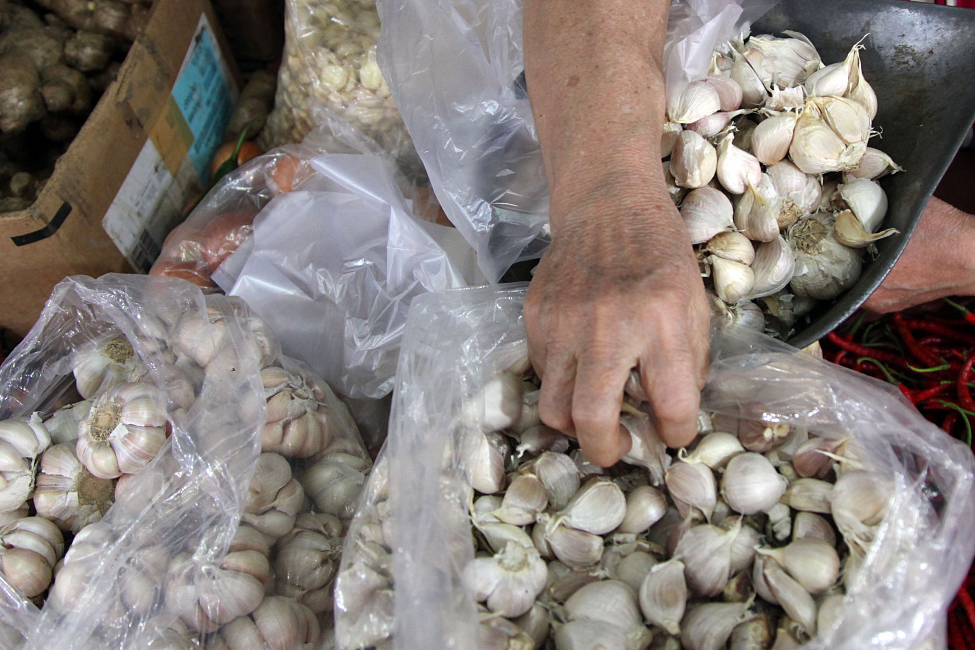 Pedagang menimbang bawang putih.