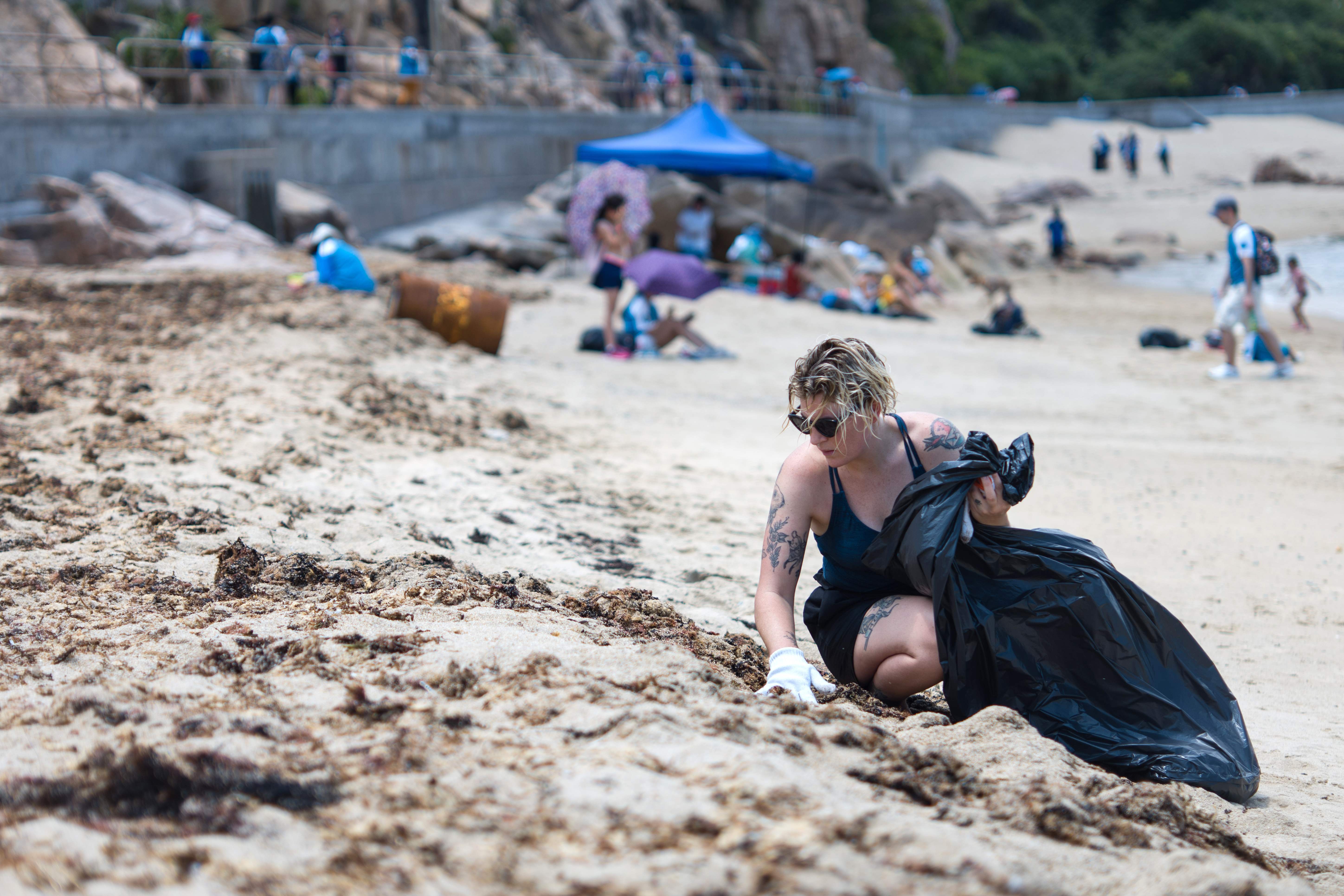Seorang relawan tengah membersihkan pantai Pulau Lamma, Hong Kong, Mei 2018