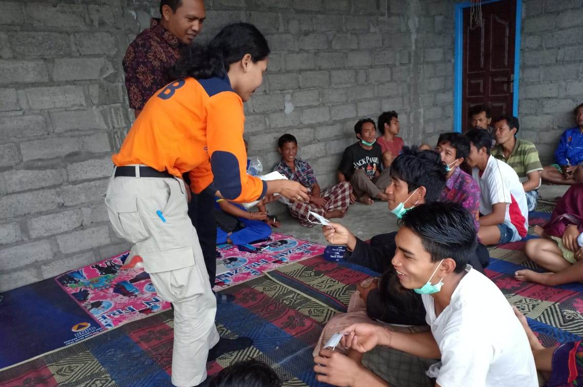 Petugas dari BPBD Karangasem, Bali menyerahkan bantuan masker kepada masyarakat Desa Ban, Kecamatan Kubu