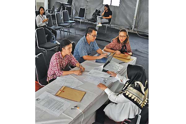 PENGURUSAN FORMULIR A5: Petugas (kanan) melayani warga yang mengurus surat pemindahan TPS atau formulir A5 di KPU Jakarta Pusat, DKI Jakarta