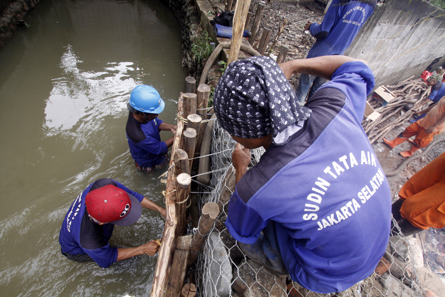 Petugas bergotong-royong memperbaiki tanggul yang jebol di kawasan Jatipadang, Jakarta Selatan, beberapa waktu lalu.