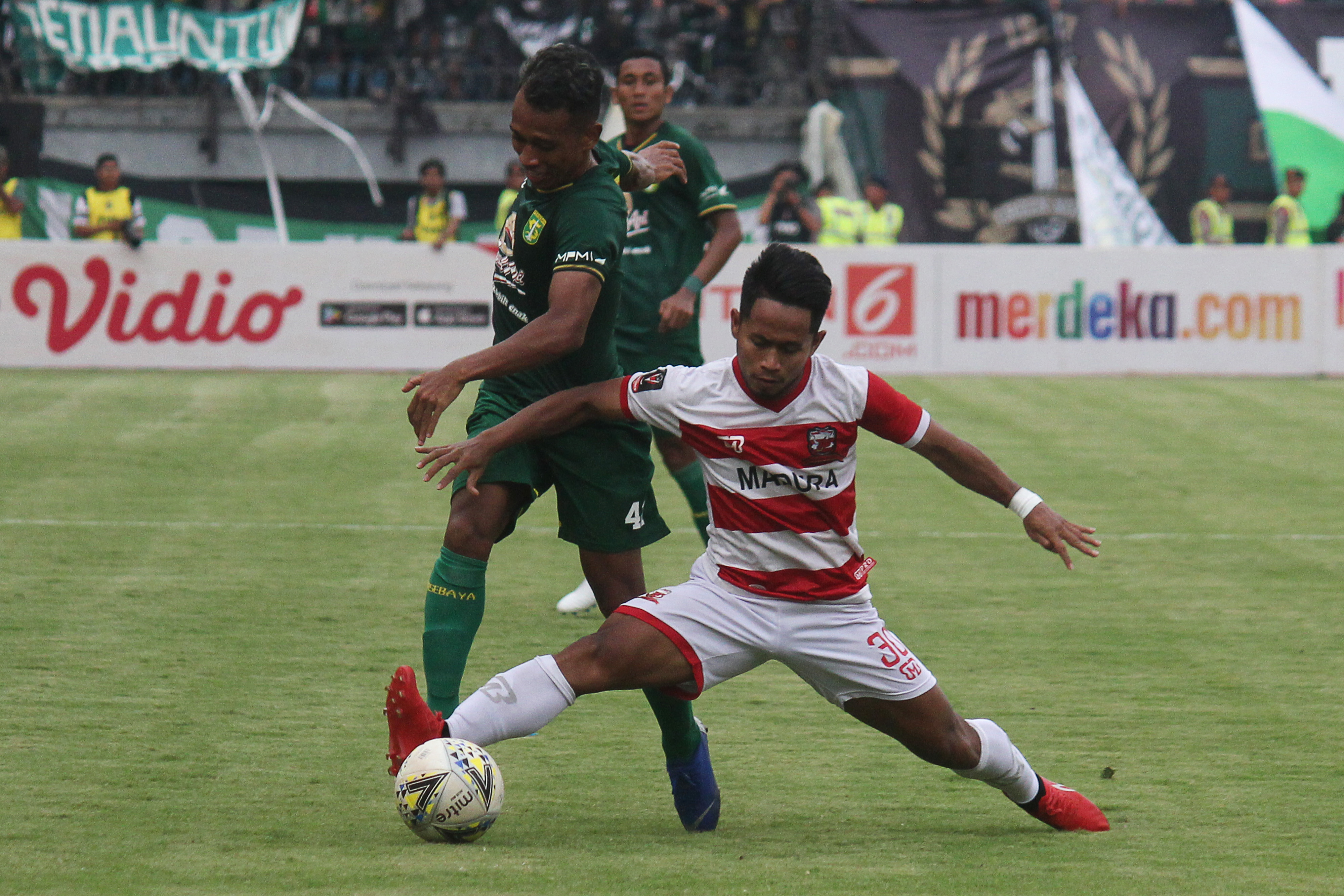  Pesepak bola Persebaya Surabaya Irfan Jaya (kiri) mencoba melewati hadangan pesepak bola Madura United Andik Vermansyah (kanan)