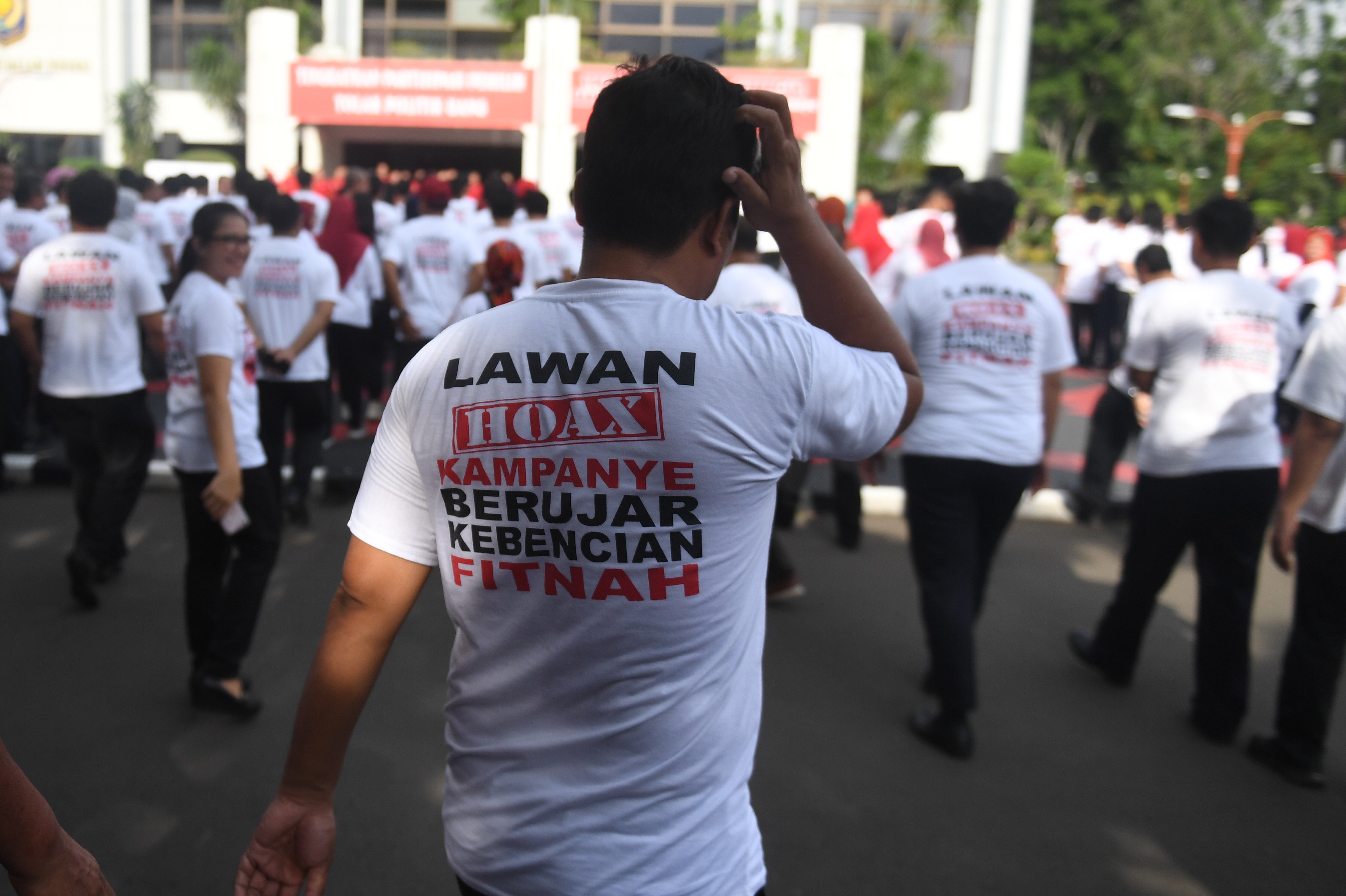 Sejumlah Aparatur Sipil Negara mengenakan kaos bertuliskan ajakan untuk melawan hoaks saat apel di Jakarta, Jumat (22/3/2019).