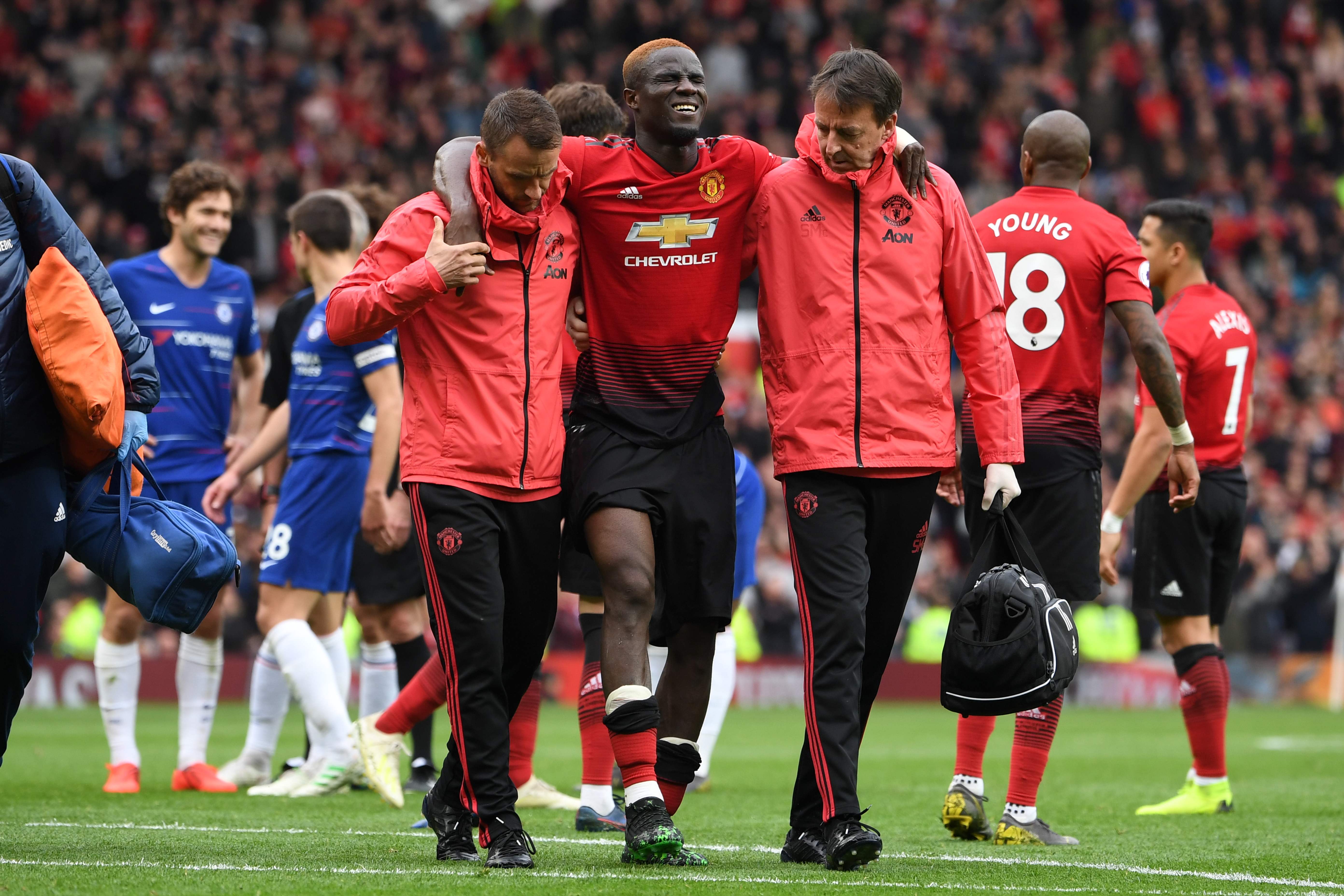 Bek Manchester United Eric Bailly (tengah) dibantu meninggalkan lapangan setelah mengalami cedera lutut dalam laga melawan Chelsea.