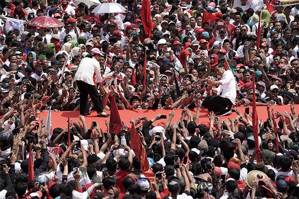 Calon Presiden nomor urut 01 Joko Widodo (kanan) disaksikan Ibu Iriana Joko Widodo melakukan swafoto bersama pendukungnya di GOR Satria, Pur