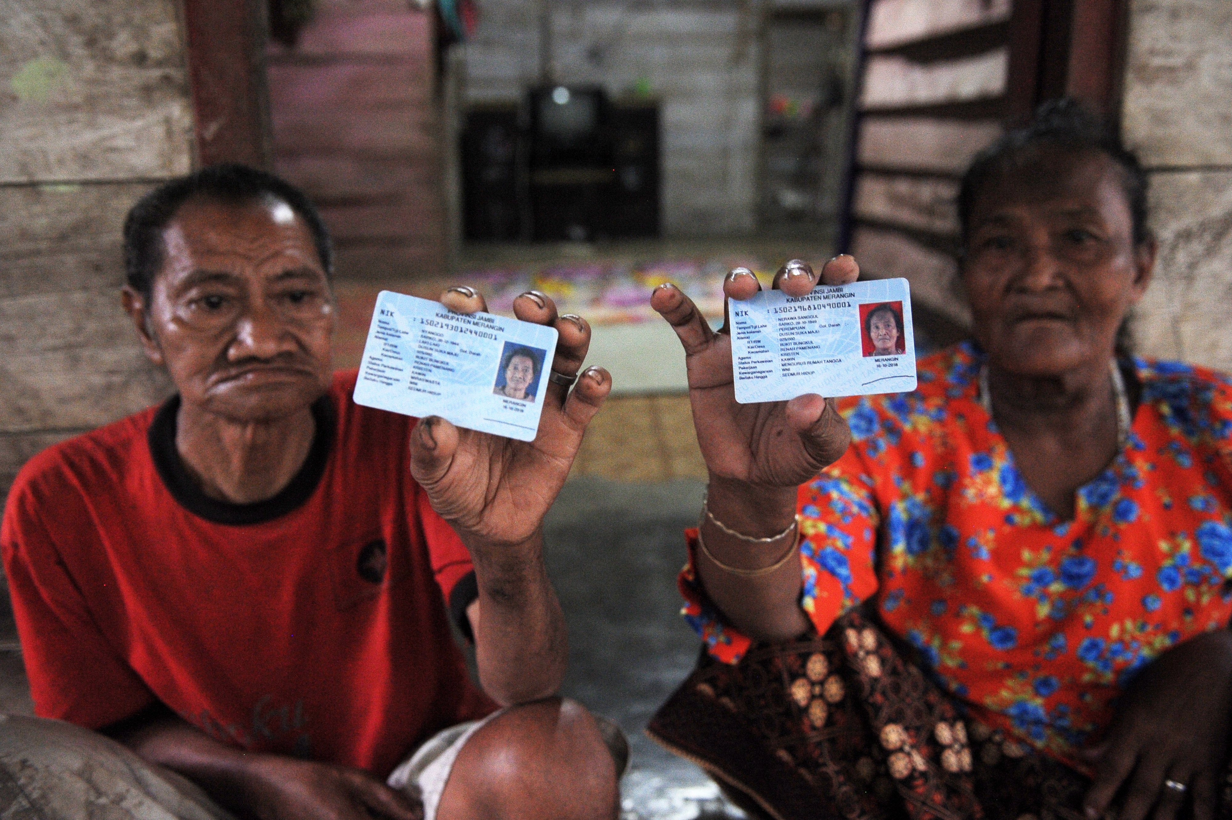 Warga Suku Anak Dalam (SAD) atau Orang Rimba Jambi, Nyanggo (75, kiri) dan Nerawa Sanggul (70, kanan) menunjukkan KT-eP miliknya 