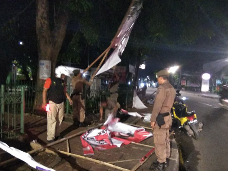 Petugas dari Kecamatan Tebet, Jakarta Selatan, melakukan pembersihan APK Pemilu 2019, Minggu dini hari, 14 April 2019.