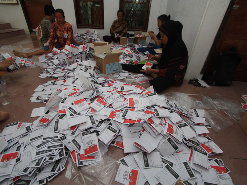 Sejumlah pekerja sedang melipat surat suara Pemilu 2019.