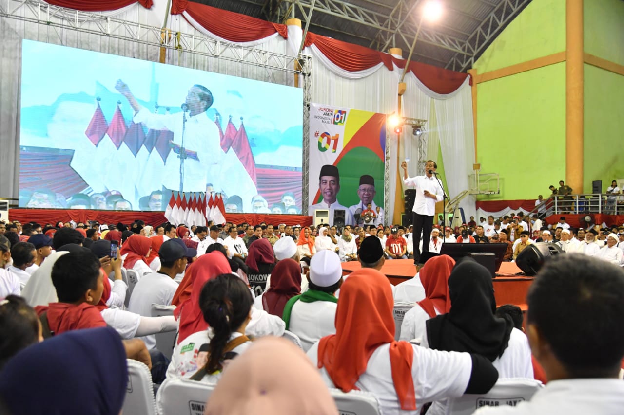 Calon presiden Joko Widodo menunjukkan KIP saat berkampanye di Ngawi, Jawa Timur