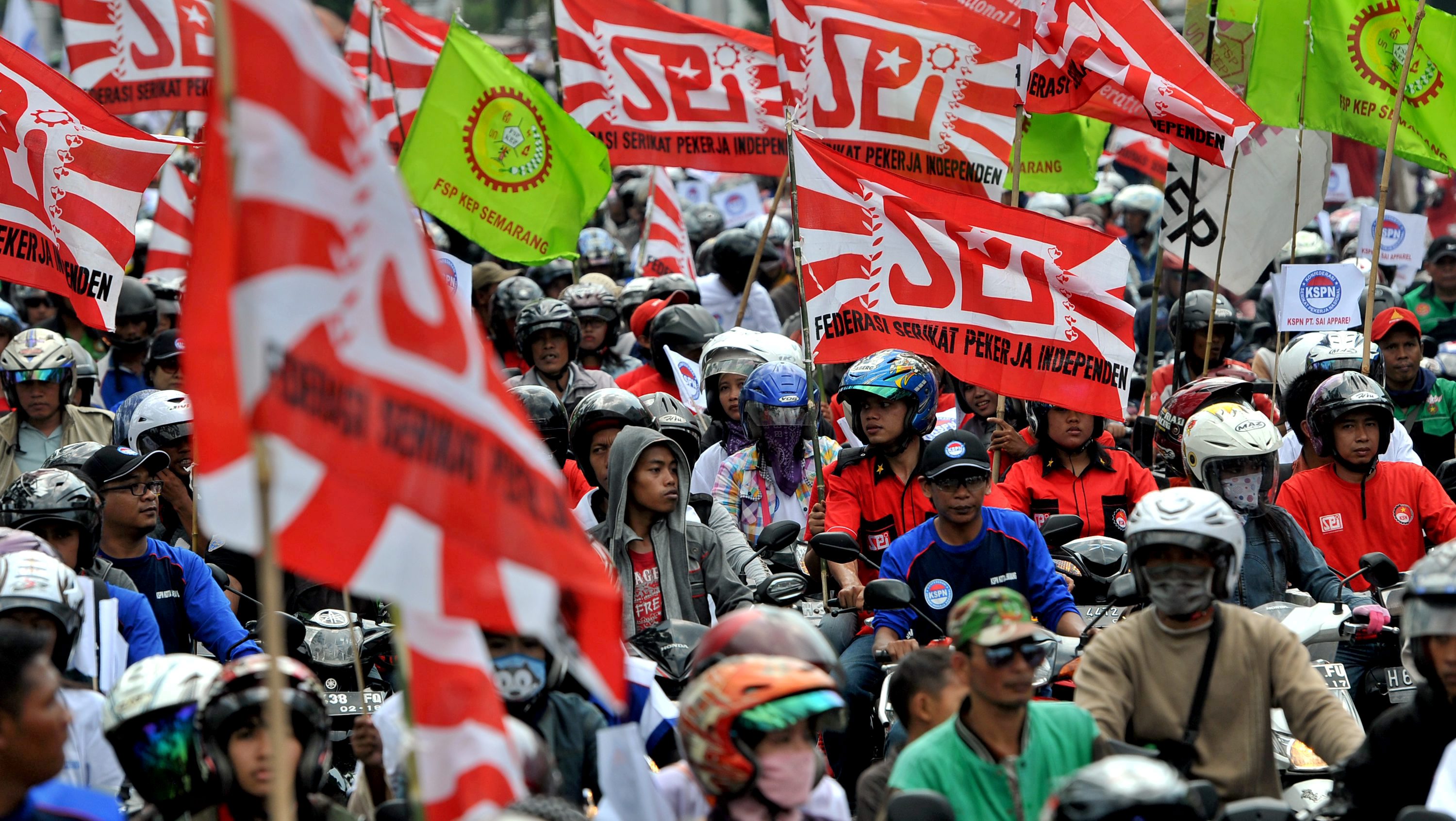 Para buruh dari berbagai elemen berkonvoi kendaraan roda dua saat berunjuk rasa memperingati Hari Buruh, di Semarang
