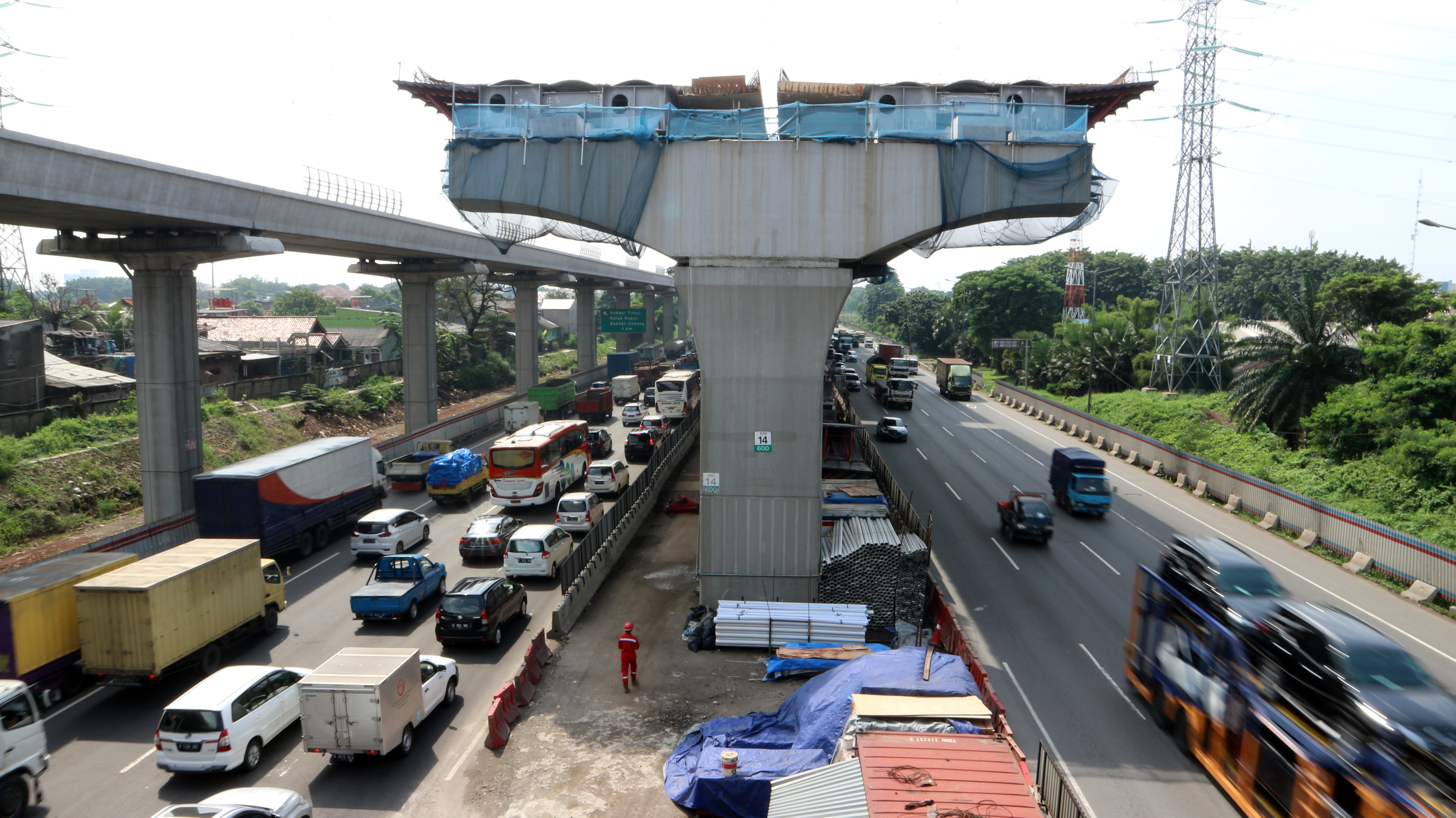 Sejumlah kendaraan melintas di bawah konstruksi pembangunan jalan tol layang (Elevated) di KM 14 Jalan Tol Jakarta-Cikampek.