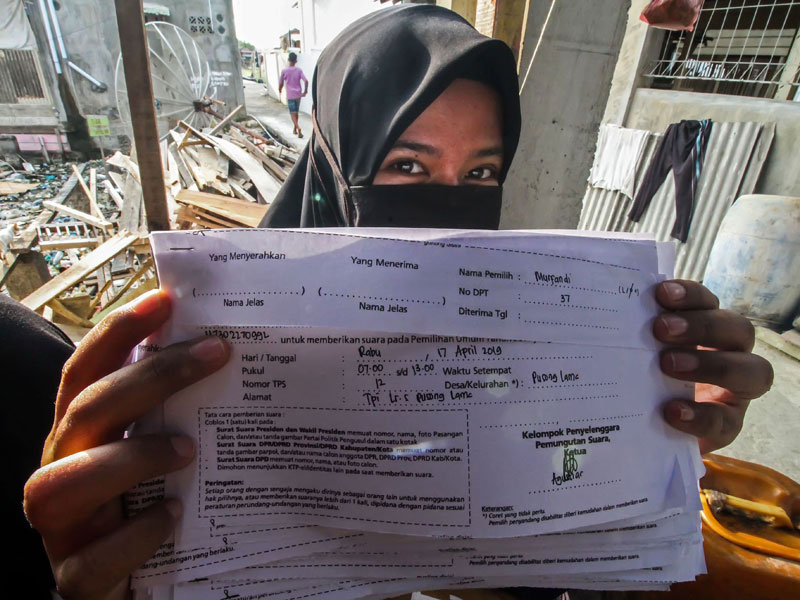 Petugas Kelompok Penyelenggara Pemungutan Suara (KPPS) menunjukkan surat pemberitahuan pemungutan suara kepada pemilih model C6.