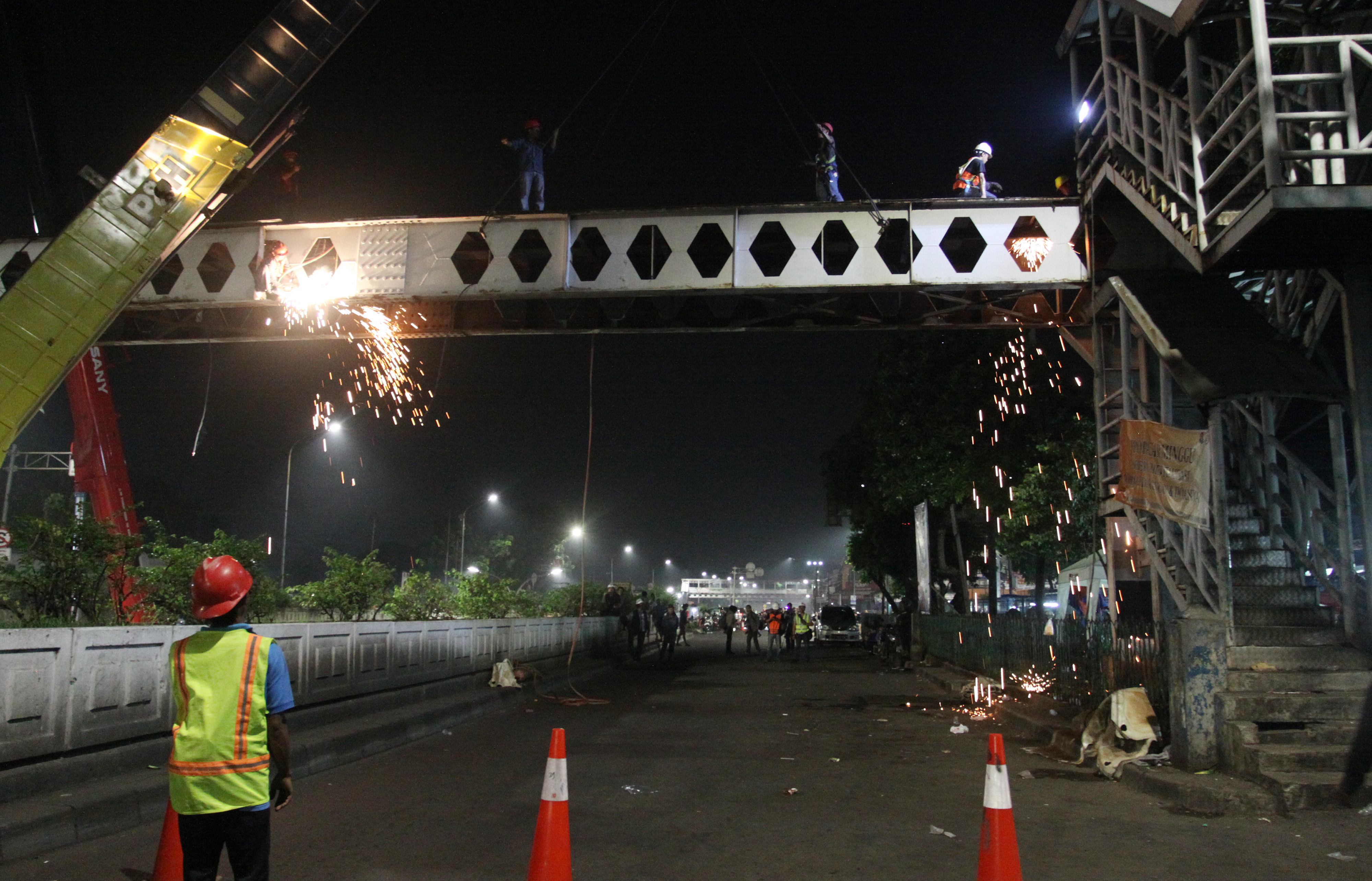 Pekerja dibantu alat berat membongkar Jembatan Penyeberangan Orang (JPO) yang rusak di Pasar Minggu, Jakarta Selatan, Sabtu (6/4)