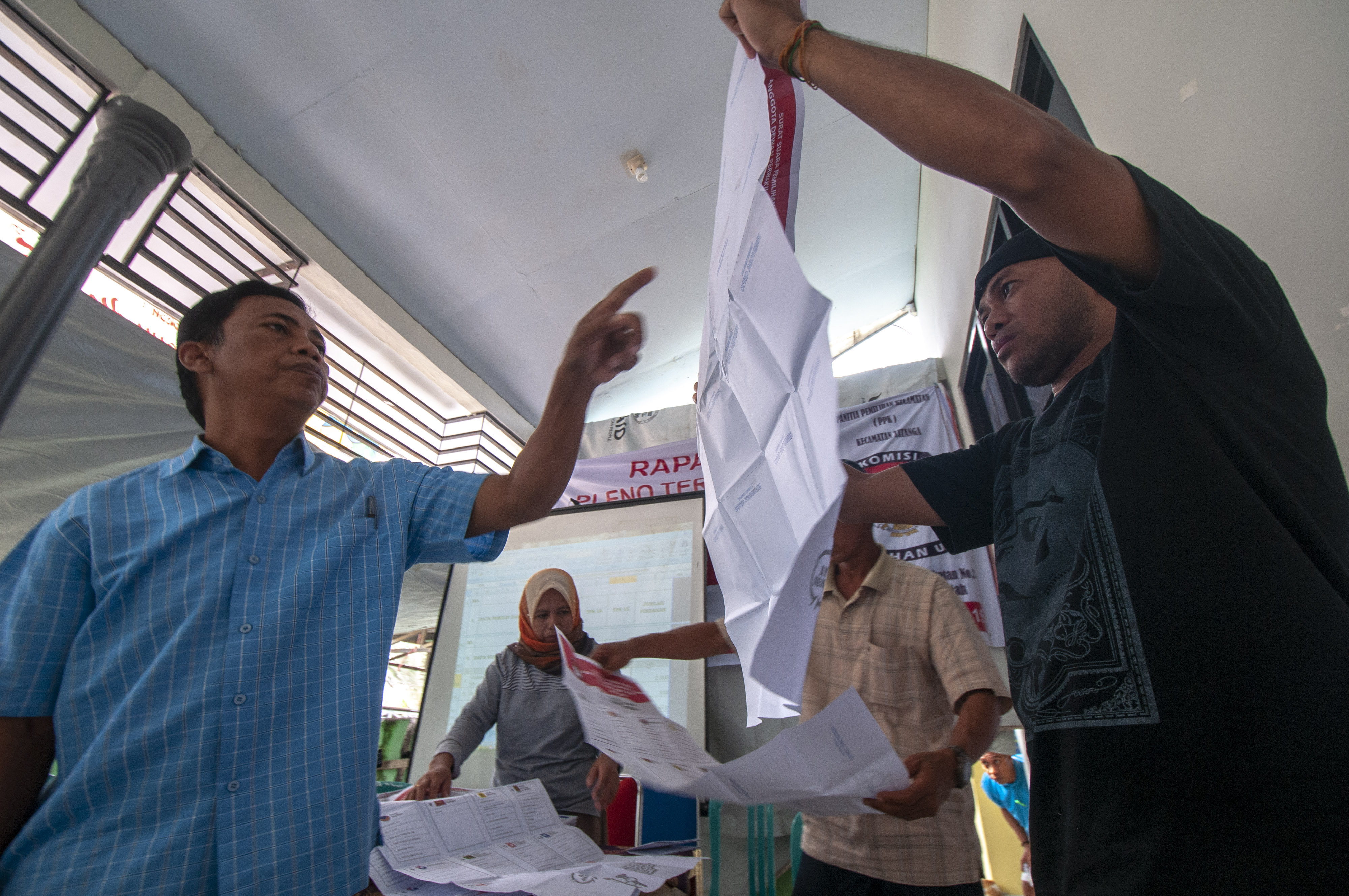 Petugas memeriksa kertas suara pada rekapitulasi tingkat kecamatan di Kantor Kecamatan Tatanga, Palu, Sulawesi Tengah.