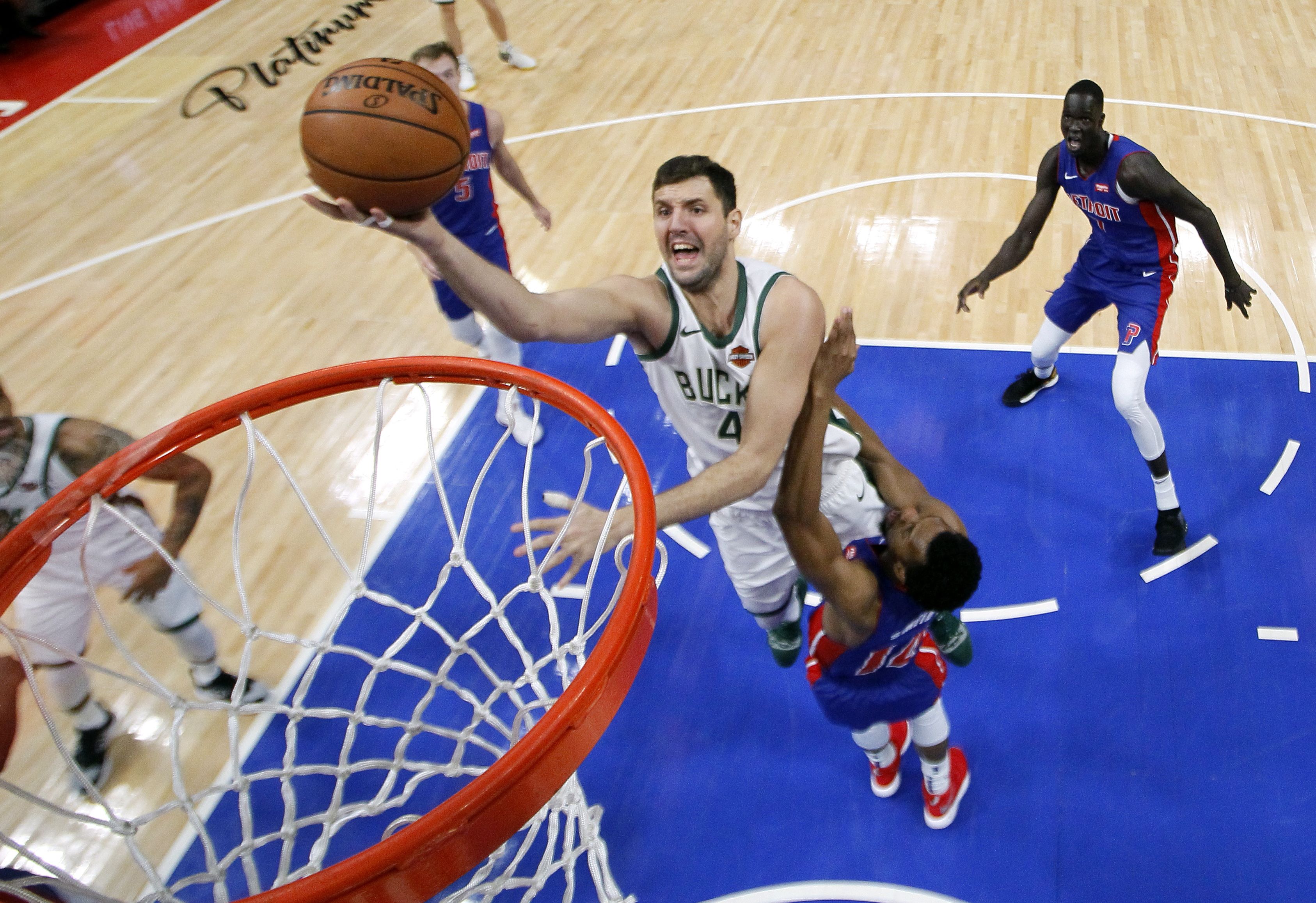 Nikola Mirotic # 41 dar Milwaukee Bucks memasukan bola dihalangahi Ish Smith # 14 dari Detroit Pistons 
