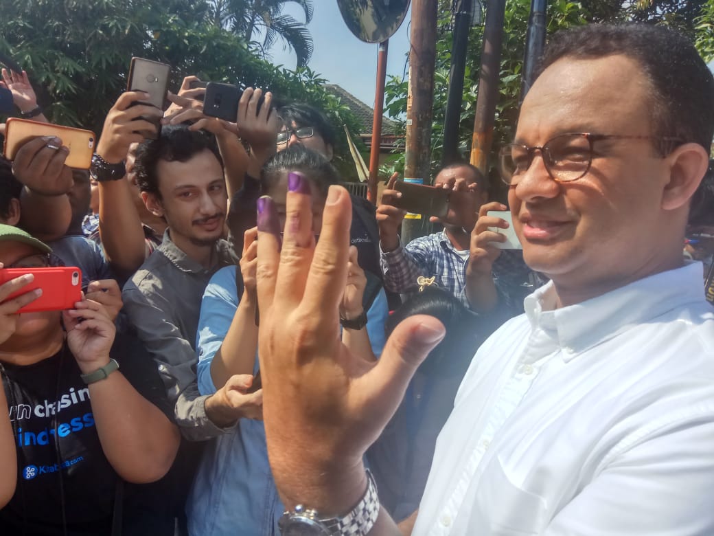 Gubernur DKI Jakarta Anies Baswedan menunjukkan jarinya usai mencoblos dalam Pemilu 2019.